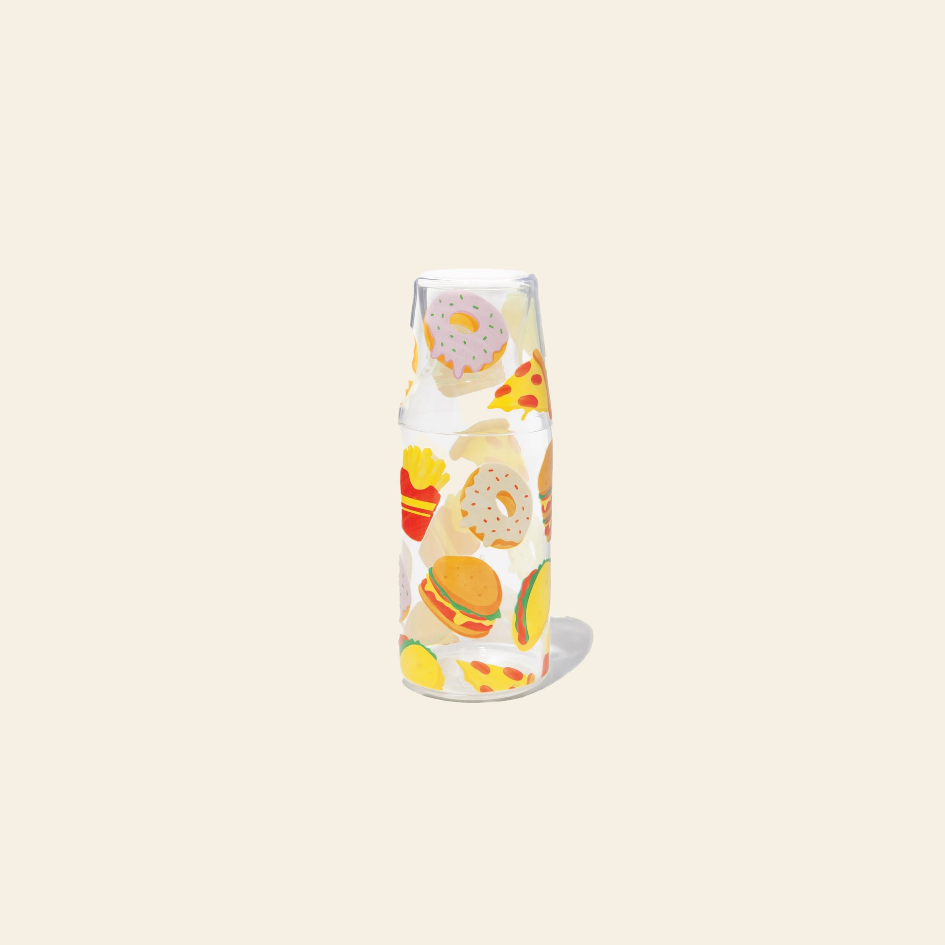 The DOIY Fast Food Jar & Glass Set by DOIY features a clear glass bottle and cup, both adorned with colorful 1950s diner-inspired fast-food icons—burgers, pizza, donuts, fries, and tacos—on a plain light beige background.