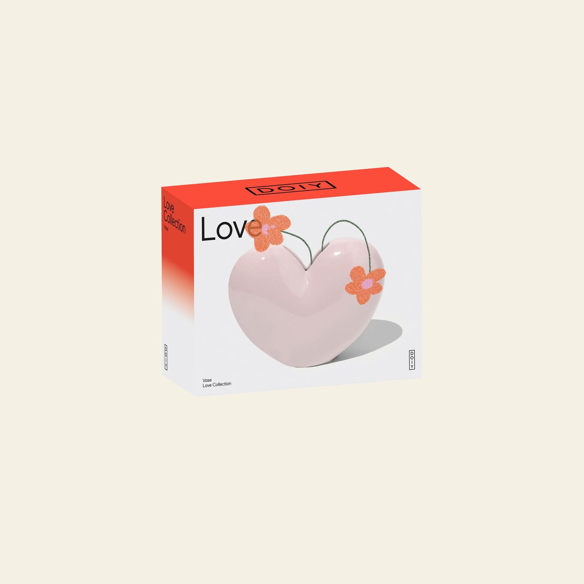 The DOIY Love Vase by DOIY features a bold pink heart shape adorned with two orange flowers and the word Love on the front, packaged in a box with a red top and white sides for a sentimental touch.