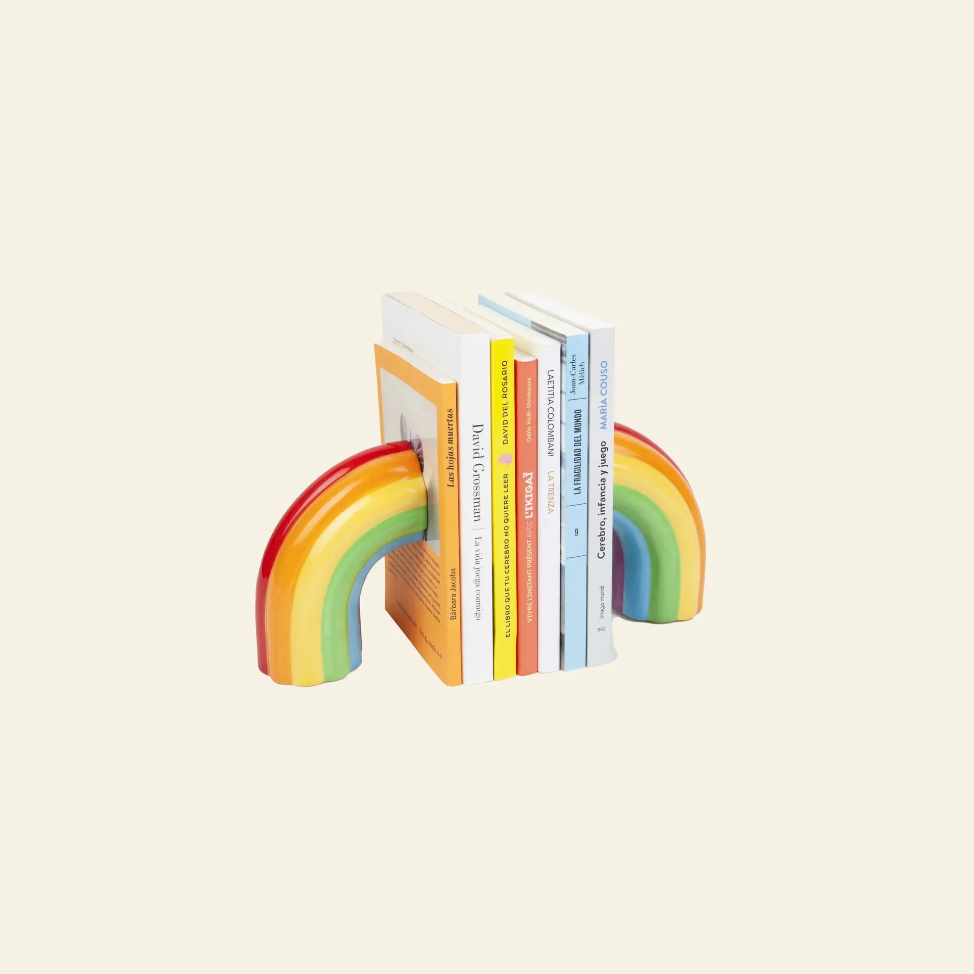 The DOIY Rainbow Bookend by DOIY adds a vibrant touch to your decor while neatly holding five books upright on a light beige surface.