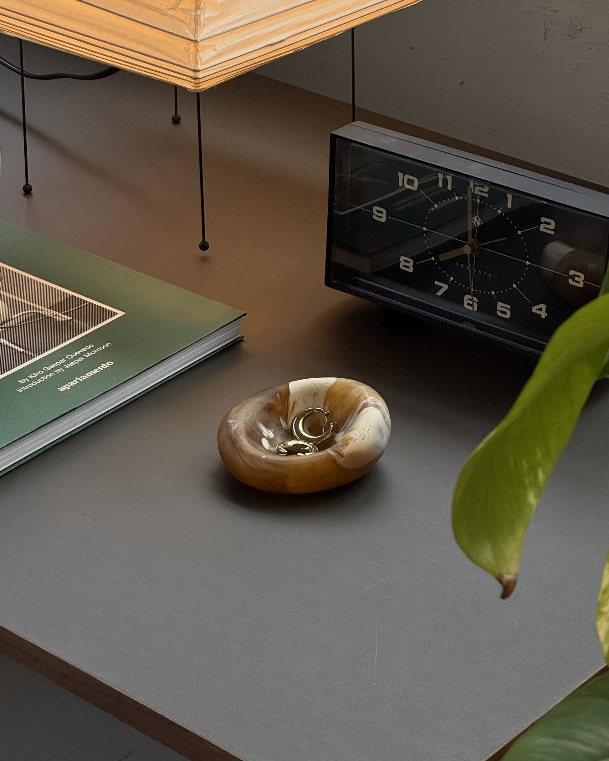 The Dinosaur Designs Small Drift Dish features handcrafted resin artistry with a marbled brown and beige finish, adding an organic touch to any plain, light beige background.