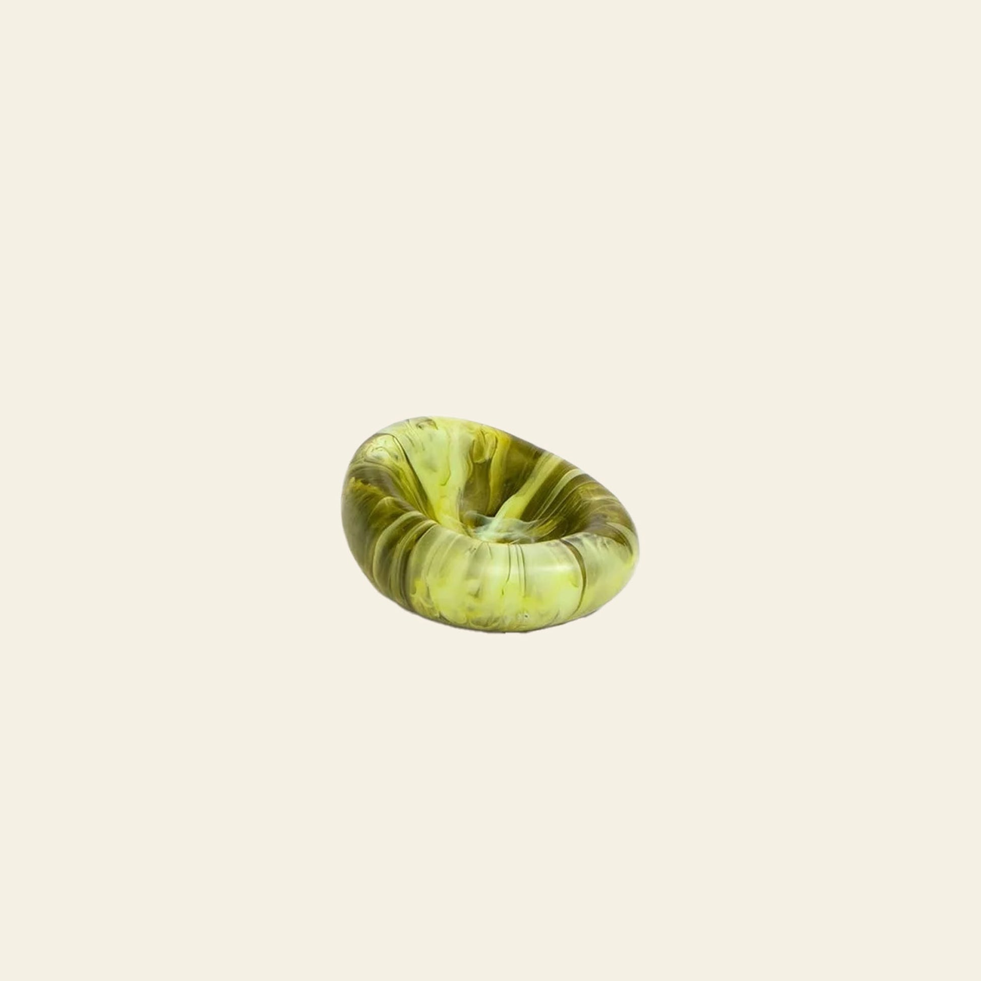 The Dinosaur Designs Small Drift Dish, handcrafted from resin in green marble pattern, features a round indented sculptural form and organic presence, presented on a plain beige background.