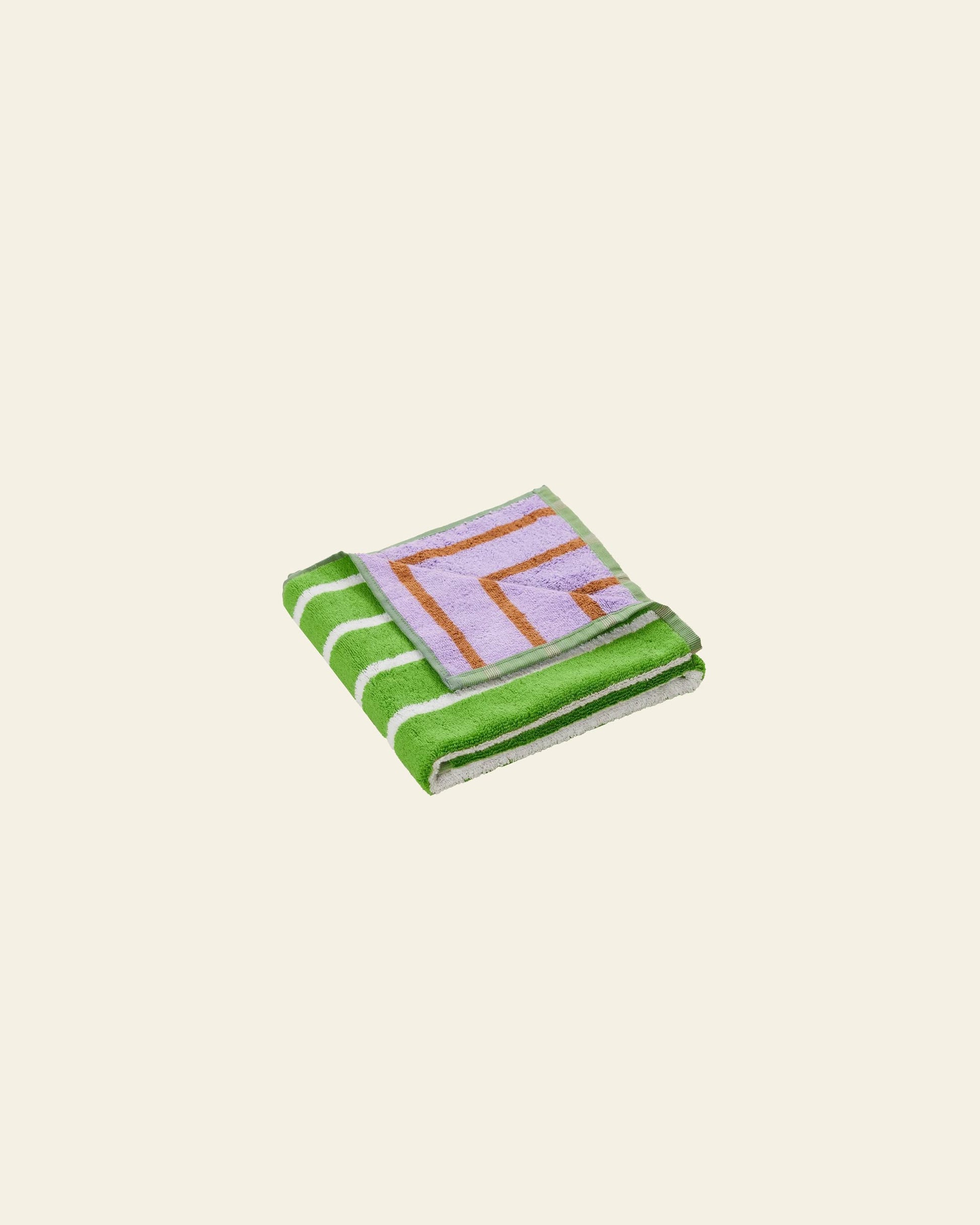 The Dusen Dusen House Stripe Glass Hand Towel, featuring green and white stripes with a purple and orange geometric accent, adds absorbent vibrance to any space on a plain light background.