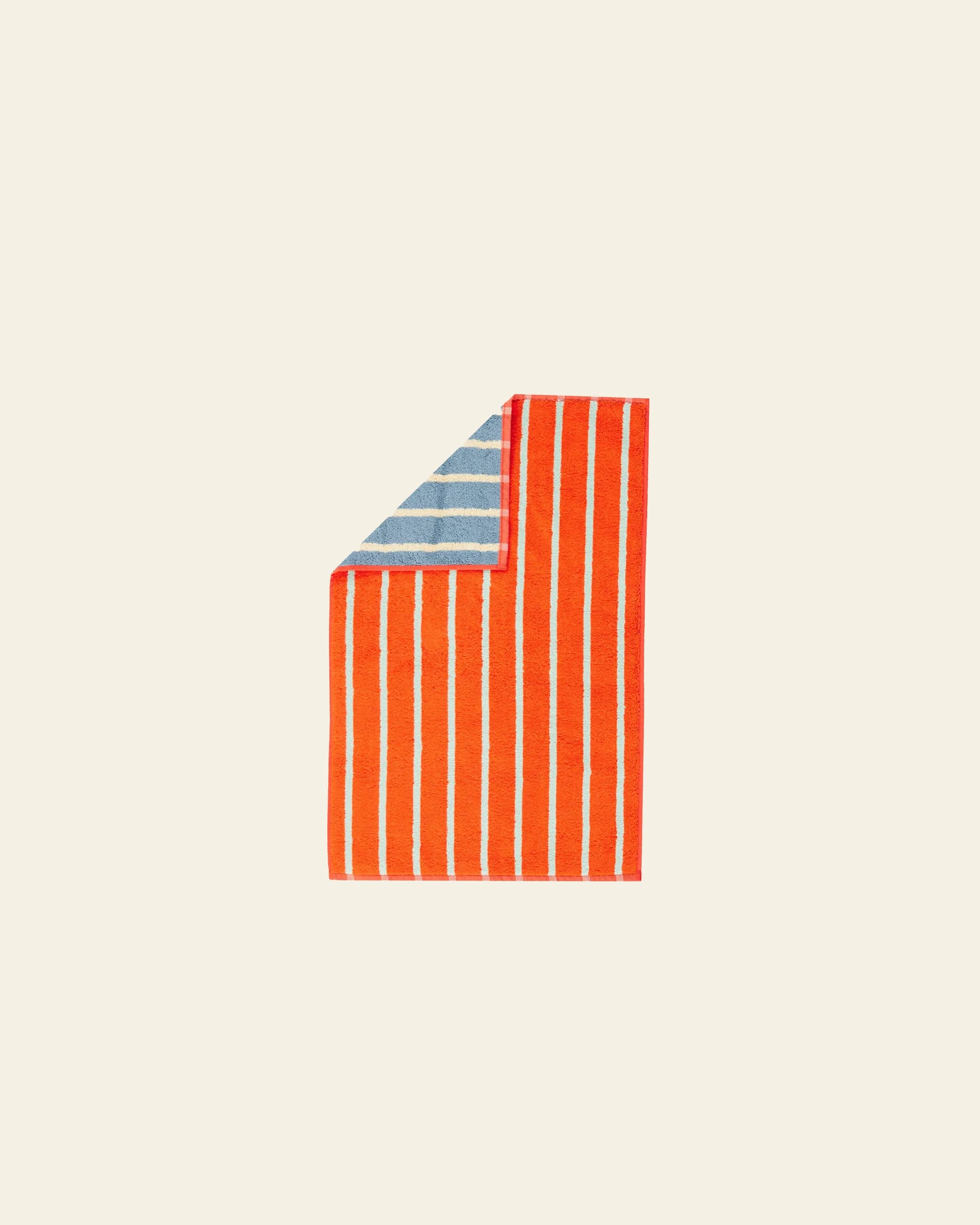 The Dusen Dusen House Stripe Stone Hand Towel by Dusen Dusen features bold red and white vertical stripes on the front, with blue and white horizontal stripes on the reverse, shown folded against a neutral background.