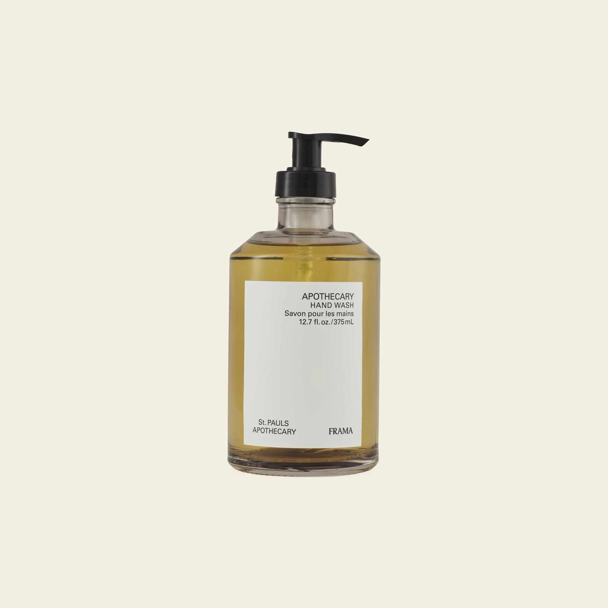 A clear pump bottle of amber-hued FRAMA Hand Wash (375ml), featuring sandalwood and organic ingredients, is displayed against a plain light background.
