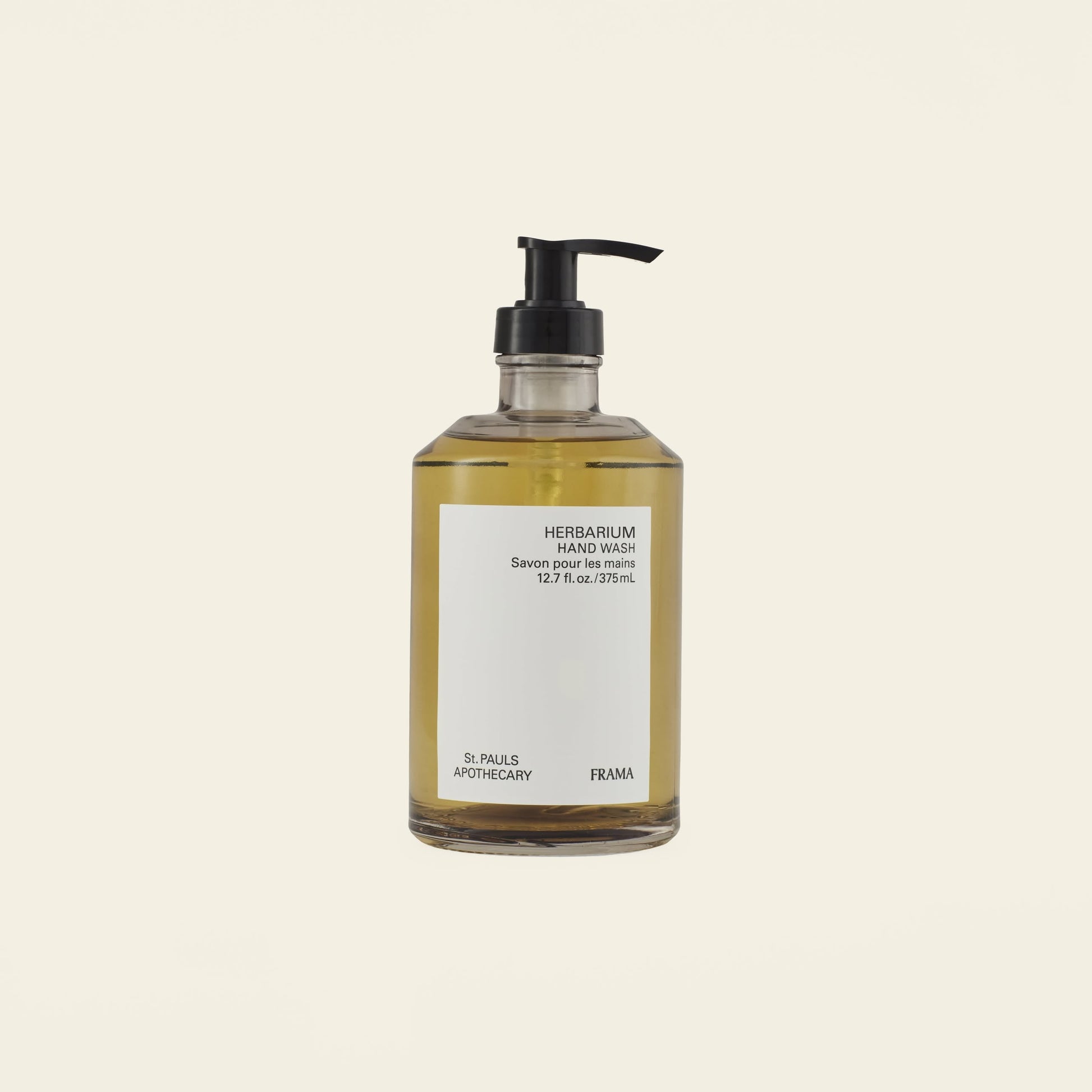 A clear pump bottle of FRAMA Hand Wash, 375ml, featuring yellow liquid and organic ingredients, is shown against a plain light background.