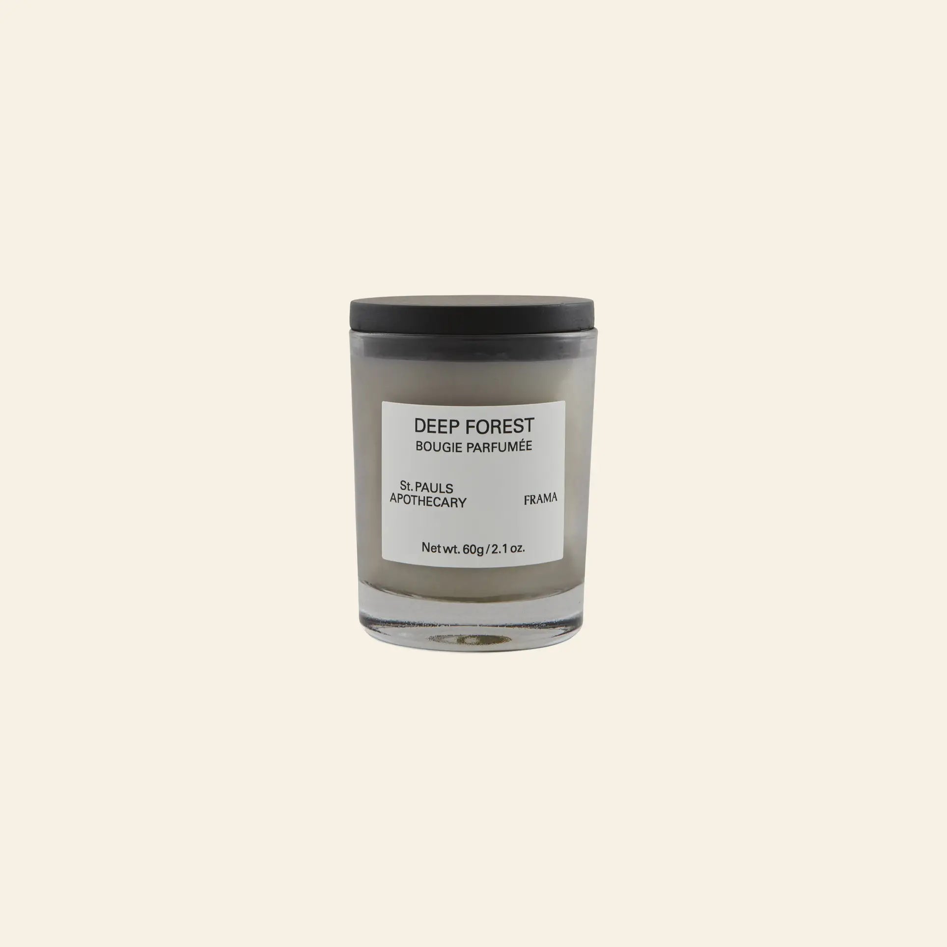 The FRAMA Deep Forest Scented Candle, 60g, features minimalist design and branding. Its glass jar holds a fragrance inspired by Abies fir woods, shown against a plain beige background.
