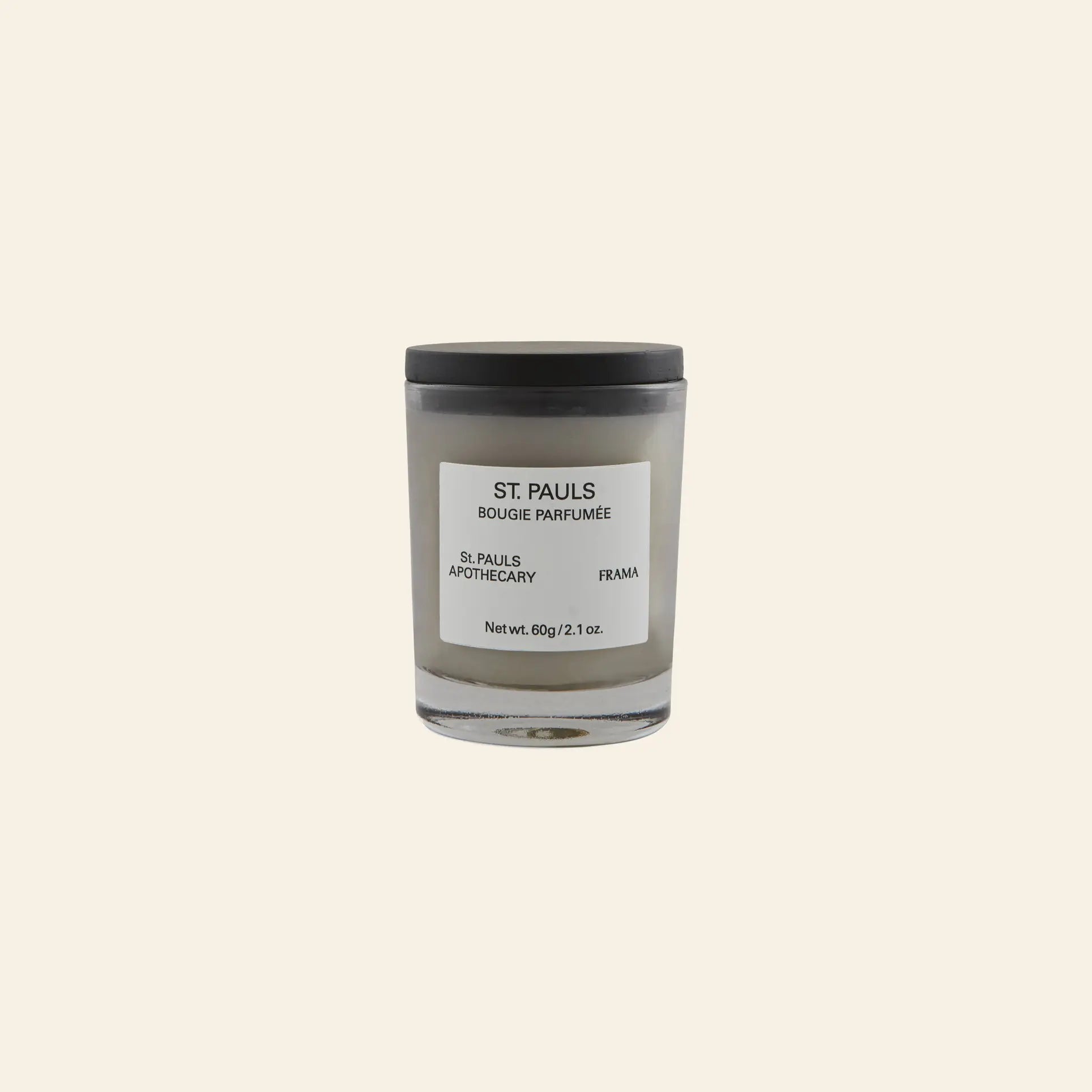 A 60g FRAMA St. Pauls Scented Candle with a black lid sits on a beige background—an elegant piece from FRAMA’s Apothecary Collection featuring an evocative aroma.