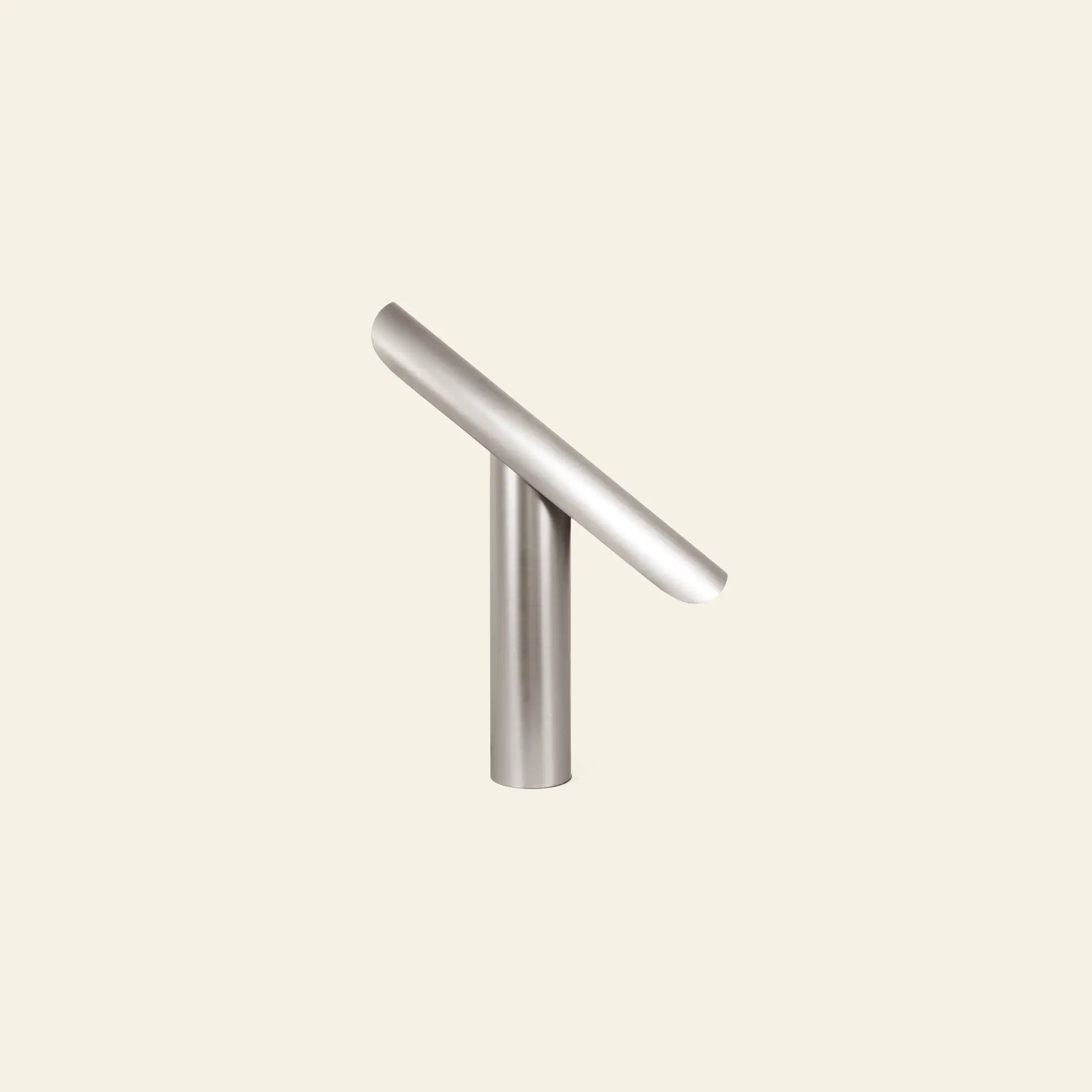 The FRAMA T-Lamp Table Lamp by FRAMA features a subtle, minimalist geometric design with brushed metal and clean lines, displayed against a plain, light beige background.