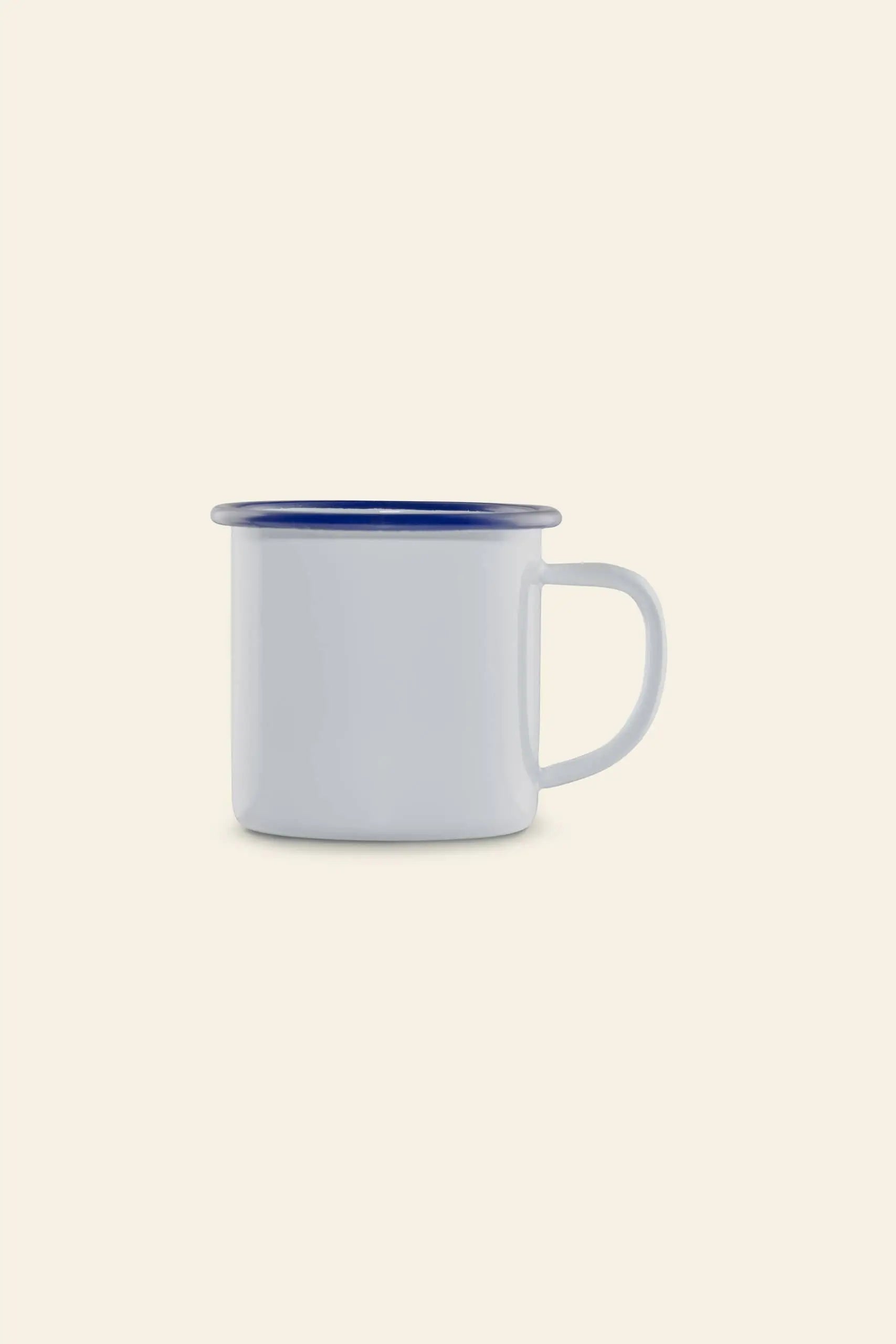 A Falcon Enamelware Mug by Falcon Enamelware, featuring white enamel with a blue rim and handle in vintage style, is shown empty and in profile against a plain beige background.