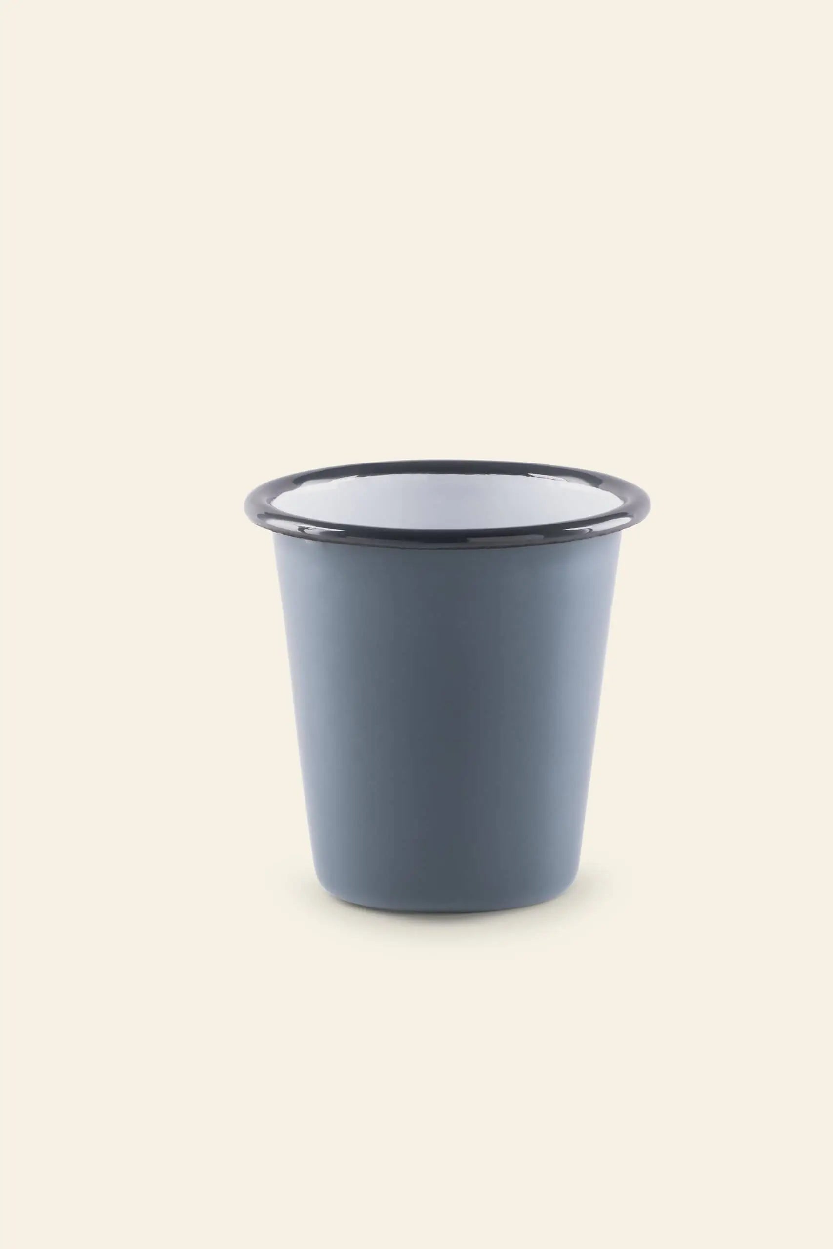 The Falcon Enamelware Tumbler by Falcon Enamelware, featuring a vintage blue design with a black rim, is centered on a plain light beige background.