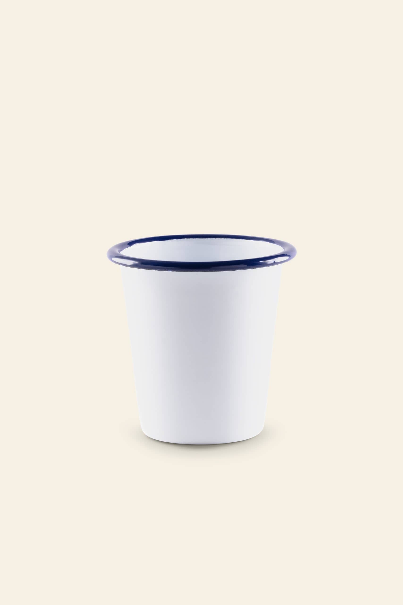 The Falcon Enamelware Tumbler by Falcon Enamelware, featuring a white enamel finish with a wide rim and blue edge for a vintage look, is displayed on a plain light beige background.