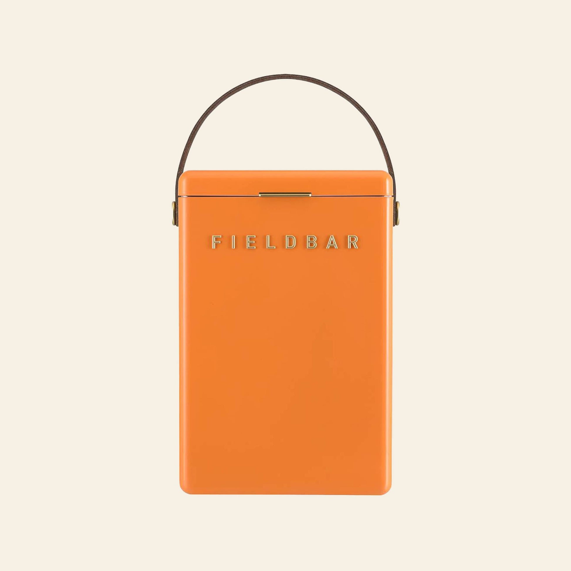 An orange Fieldbar Drinks Box ice box with a brown handle and gold clasp, featuring the gold FIELDBAR logo on the front, is shown against a plain light background.