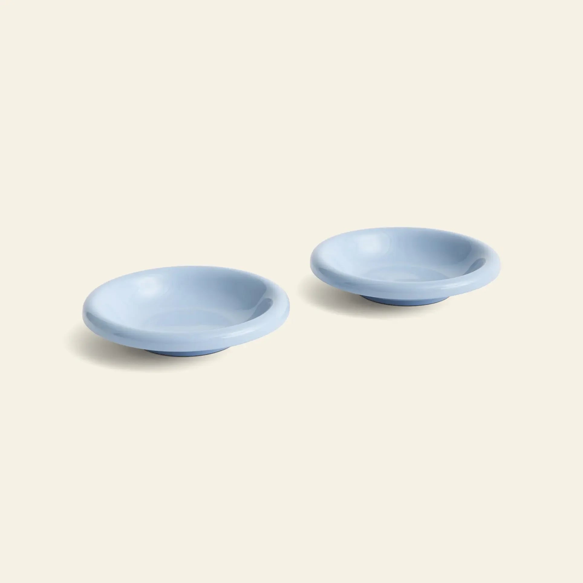 Two HAY Barro Bowl ceramic dishes from HAY, sold as a set of 2, are displayed side by side in light blue terracotta on a plain light beige background.