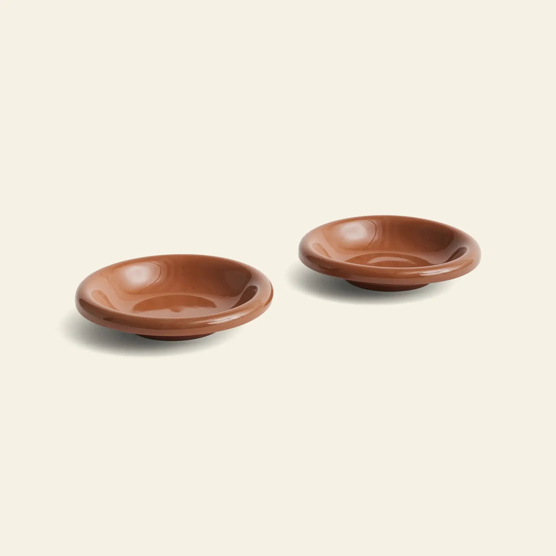 The HAY Barro Bowl, Set of 2 by HAY features two smooth terracotta bowls crafted by a Portuguese designer, shown side by side against a plain light background.