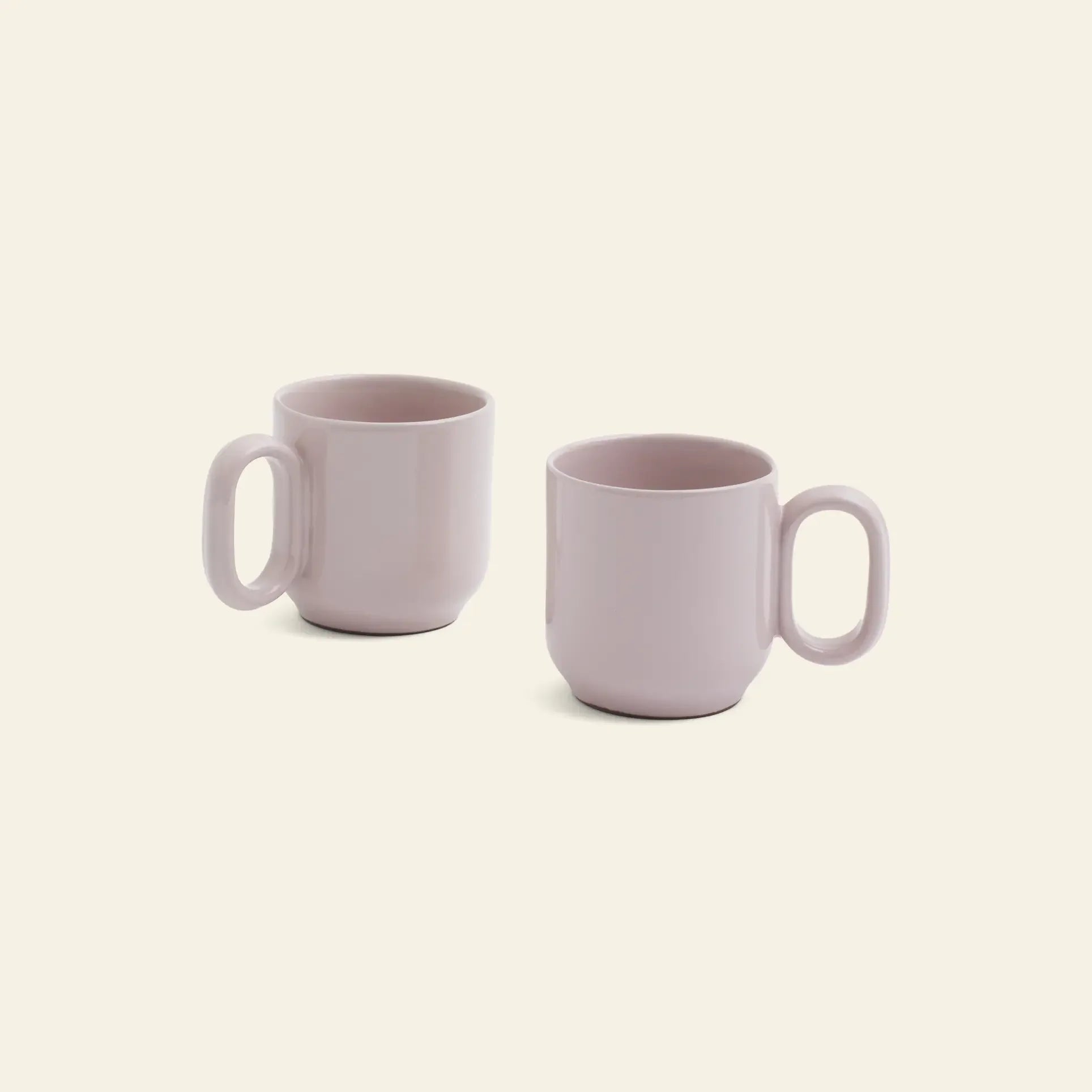 A set of two HAY Barro Cups by HAY, featuring light pink ceramic and large oval handles, is displayed on a plain light beige background.