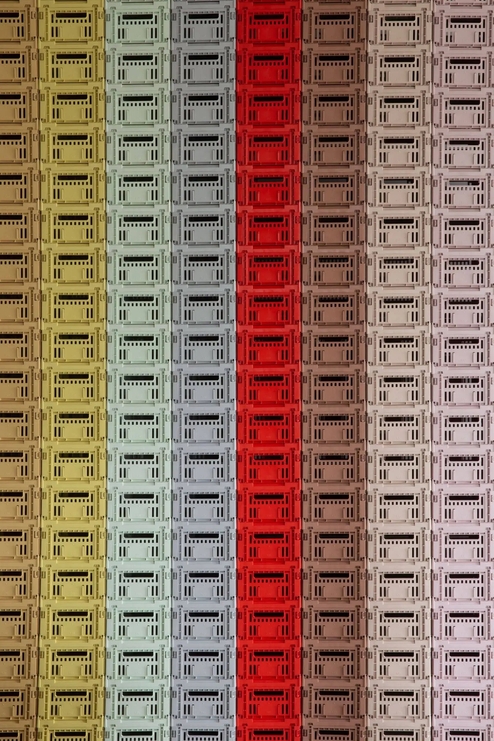Rows of stacked cassette tapes in yellow, green, blue, red, brown, pink, and beige form a vertical striped pattern reminiscent of HAYs Colour Crate Small—an eye-catching storage solution for an organized living space.