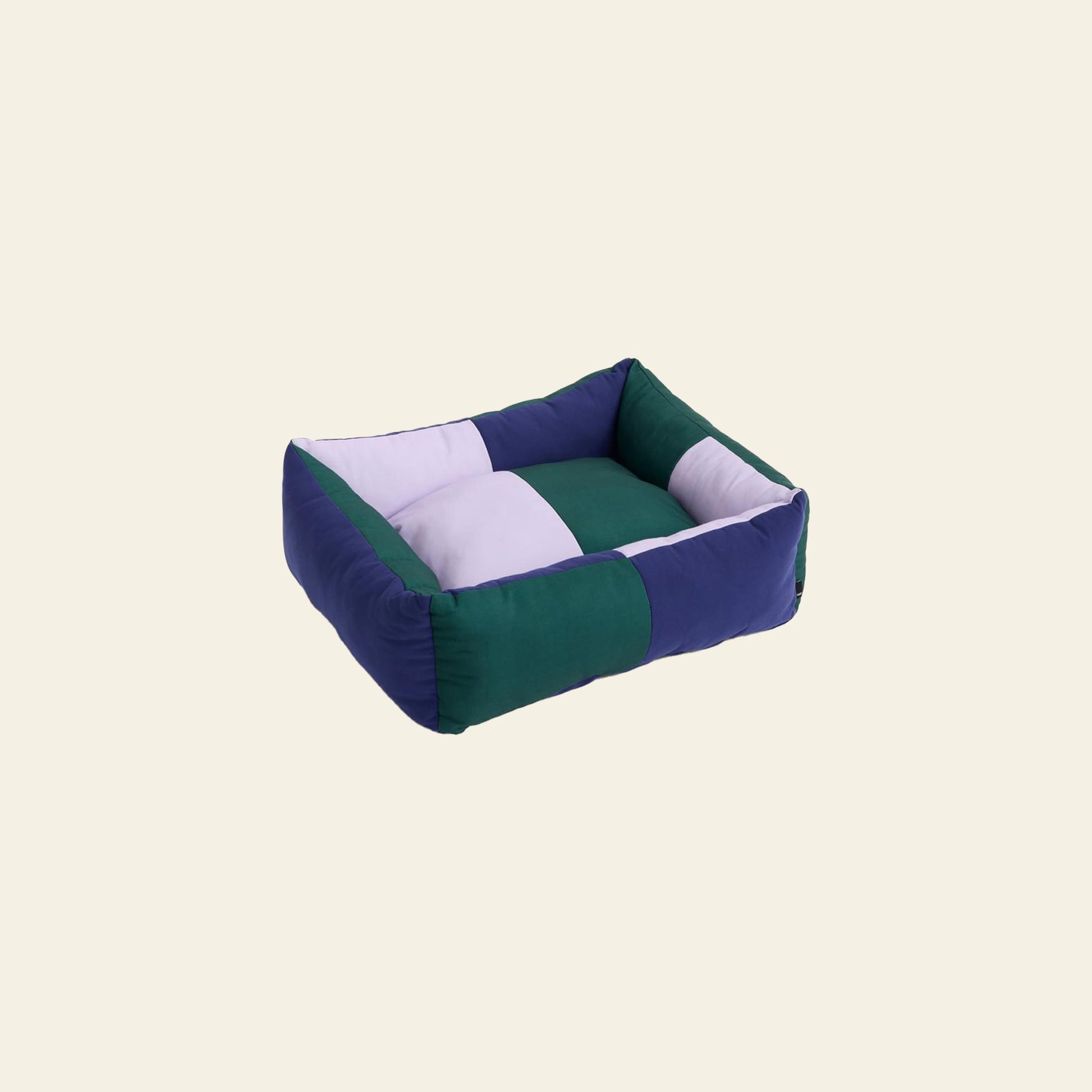The HAY Dogs Bed S in Green/Lavender/Blue by HAY is a rectangular dog bed with raised sides and a colour-blocked patchwork design, crafted from recycled polyester and displayed on a plain light background.