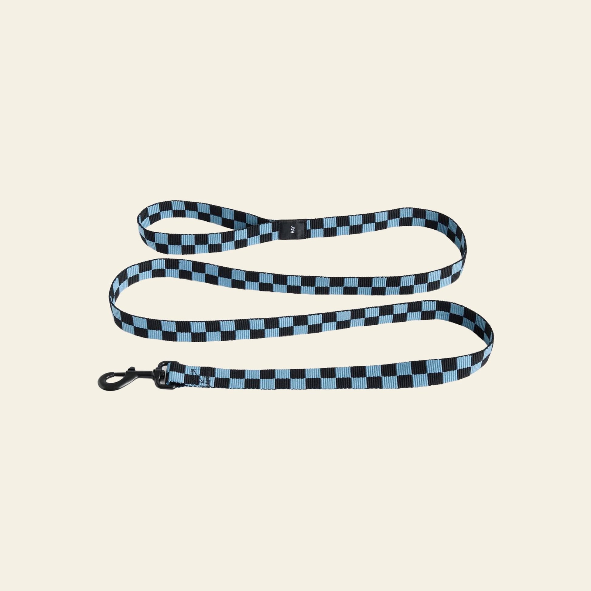 A HAY Dogs Leash Flat Check by HAY, featuring blue and black checks and a sturdy black metal clasp, made from recycled polyester, is displayed on a plain light beige background.