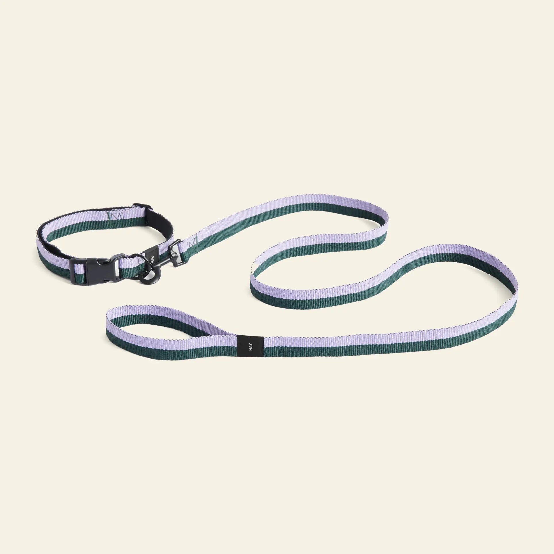 The HAY Dogs Leash Flat M/L, in green and lavender and made from recycled polyester, is displayed with matching accessories by HAY on a light beige background.