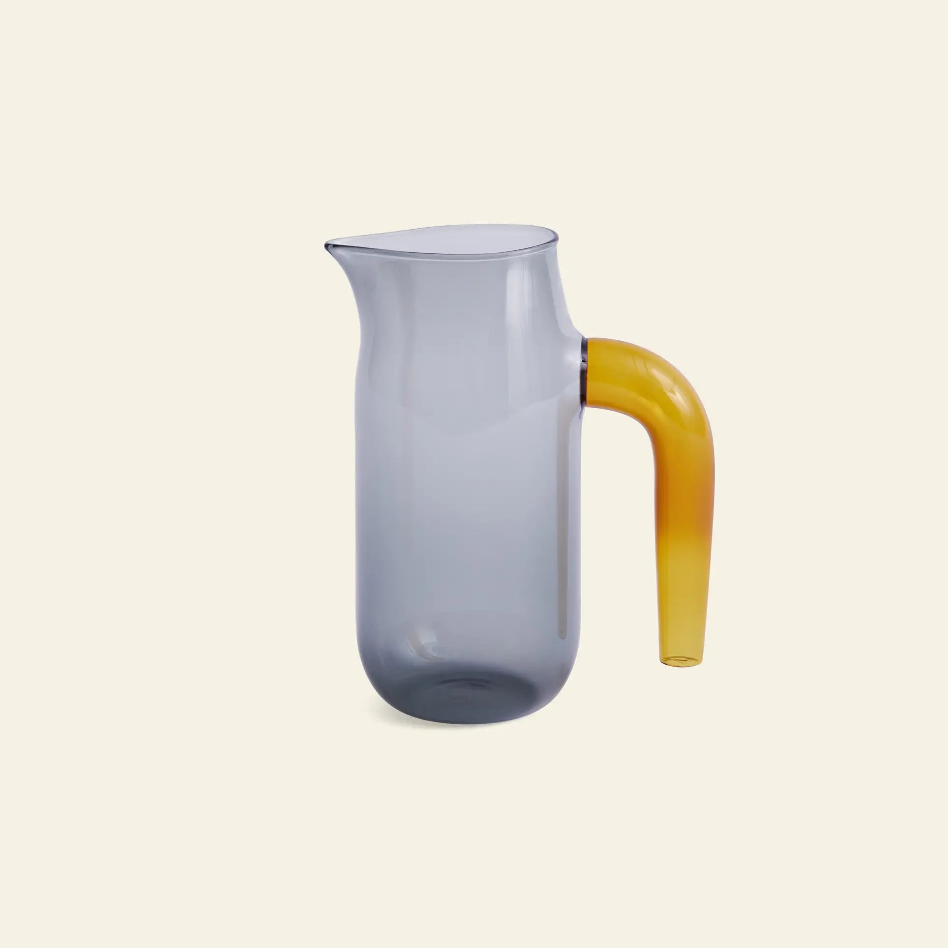 The HAY Jug L by HAY features a modern borosilicate glass design with a translucent gray body, distinctive rim, and curved amber-colored handle, displayed on a plain light beige background.