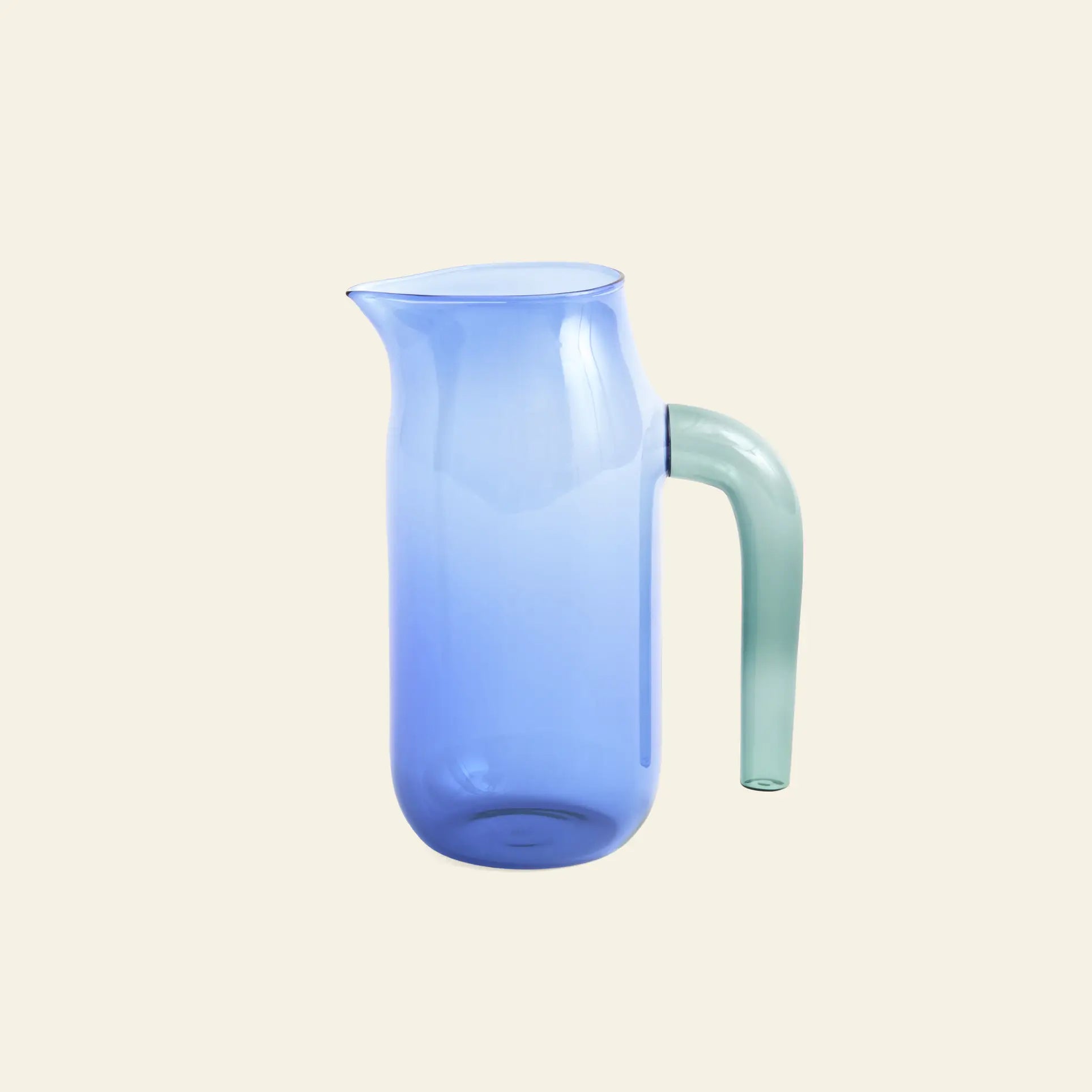 The HAY Jug XL by HAY features translucent blue borosilicate glass with a cylindrical body, slightly flared spout, and curved light green handle, displayed against a plain off-white background.