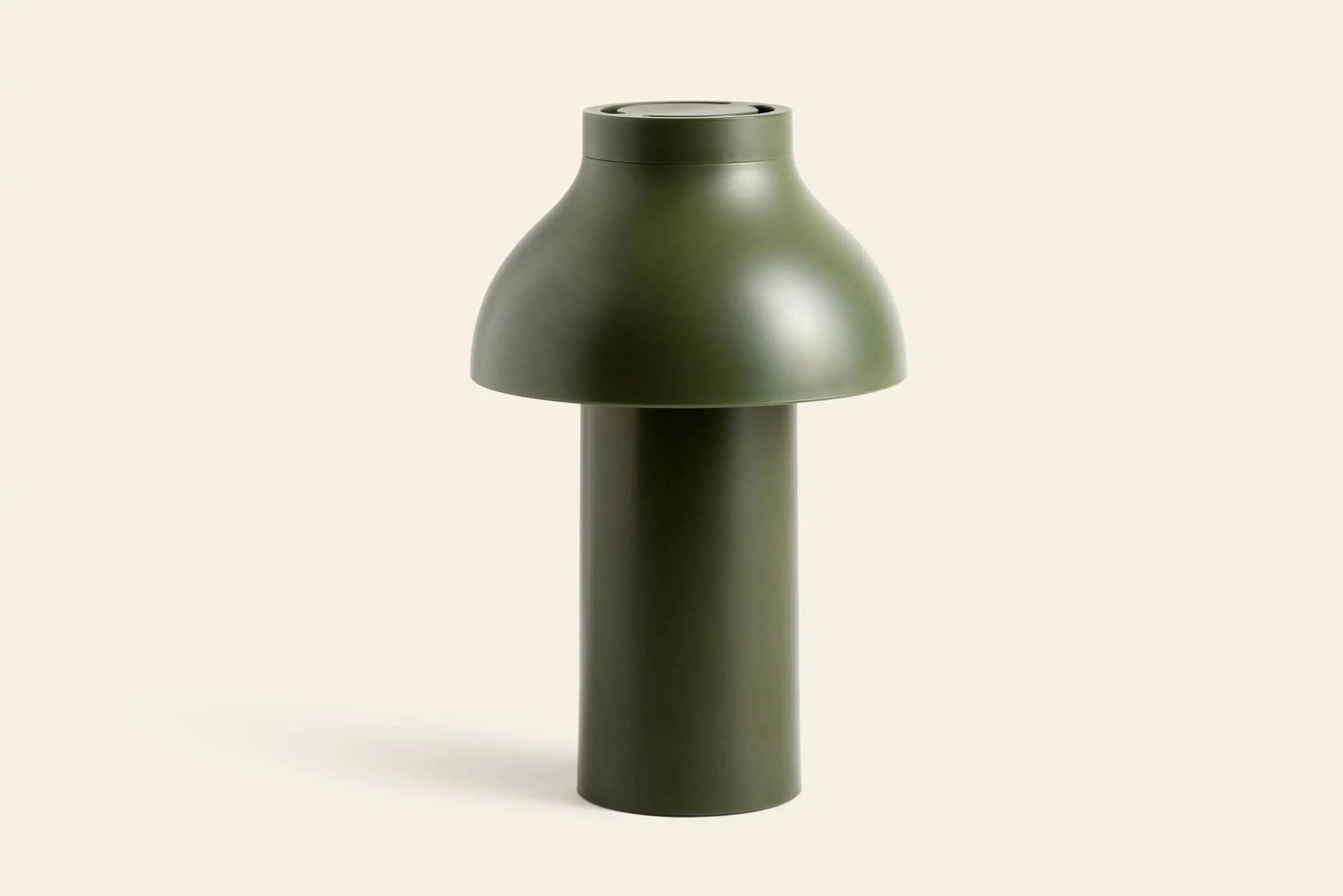 The HAY PC Portable Lamp by HAY is a modern, minimalist olive green desk lamp featuring a wide, rounded shade and cylindrical base, shown against a plain light beige background.