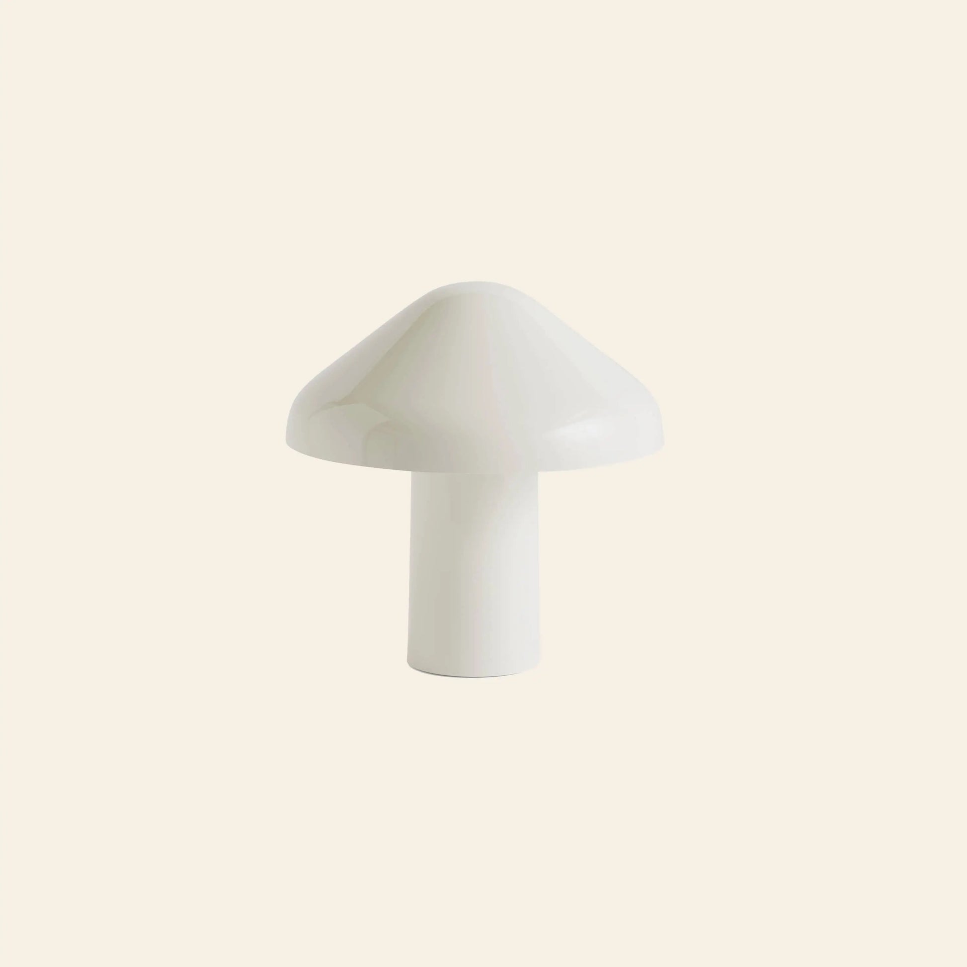 The HAY Pao Portable Lamp by HAY, designed by Naoto Fukasawa, features a minimalist white mushroom shape and sits centered on a light beige background—an elegant statement in portable lighting design.