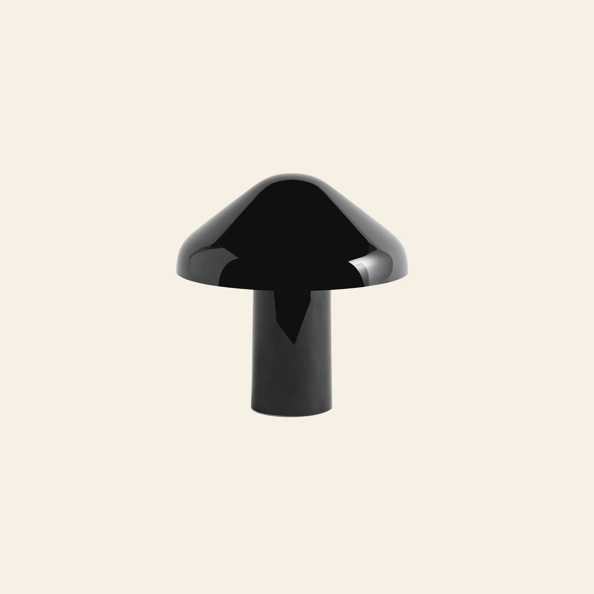 A glossy black HAY Pao Portable Lamp by HAY, shaped like a mushroom with a domed top and cylindrical stem, is centered against a plain light beige background.