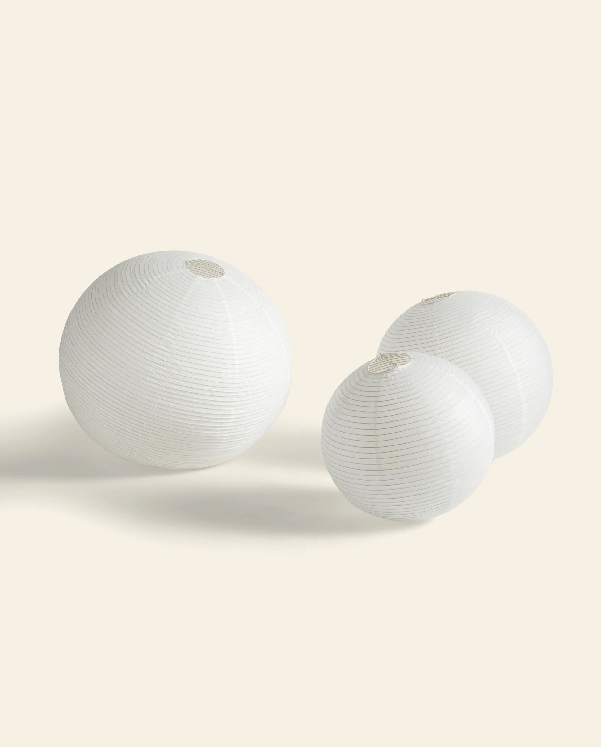 The HAY Paper Shade 80cm Dia. With Pendant Cord Set by HAY rests on a light beige background, its white round form casting soft shadows.