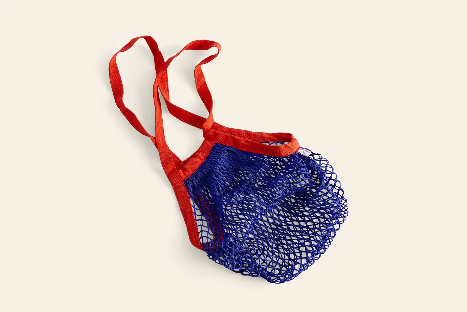 The HAY Sobremesa Market Net Bag by HAY, featuring blue mesh and bold red handles, is displayed flat on a light beige background—a stylish and practical choice for carrying groceries.