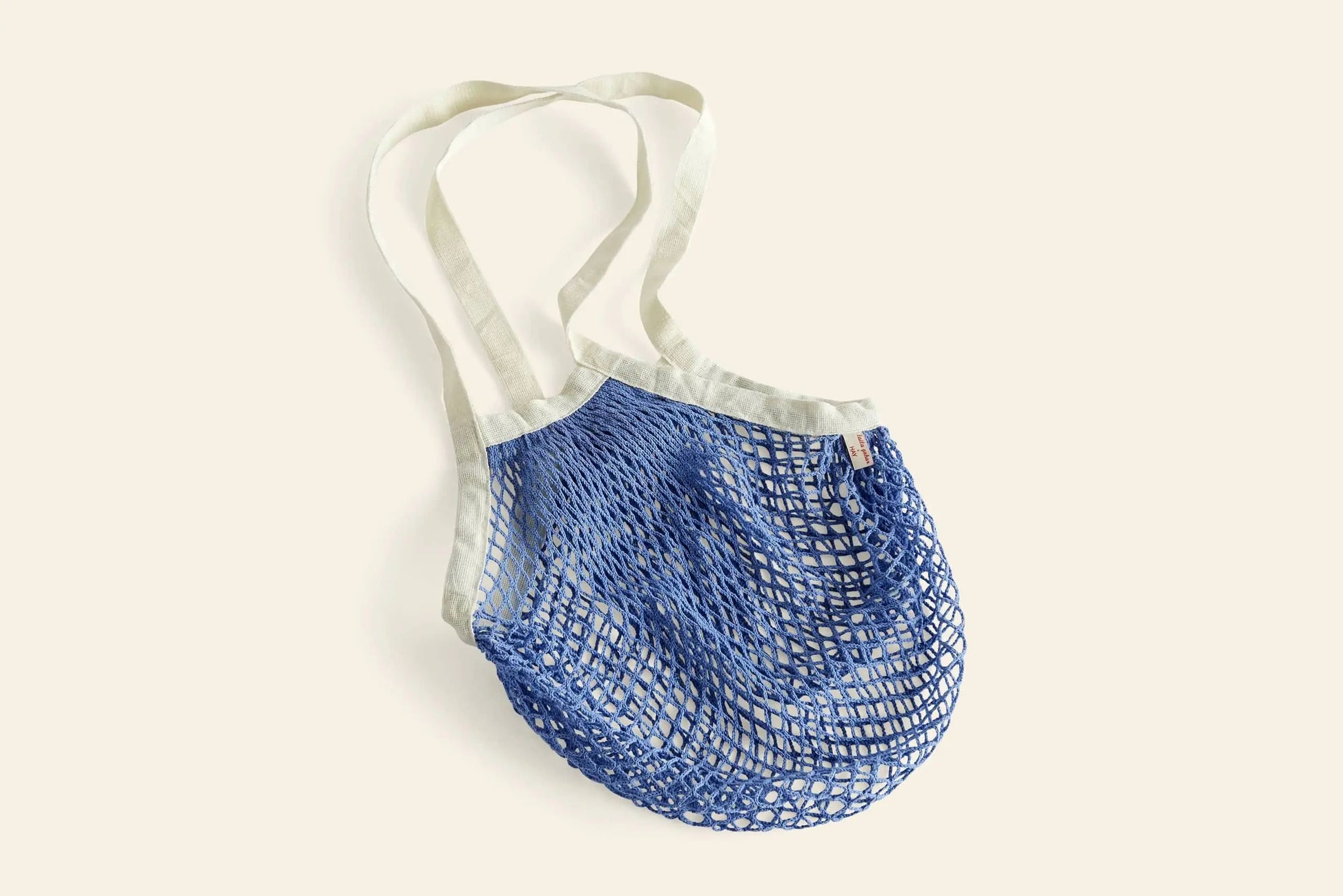 The HAY Sobremesa Market Net Bag by HAY features white handles and a light blue netted body, making it a stylish and reusable option for carrying groceries. Shown on an off-white background.