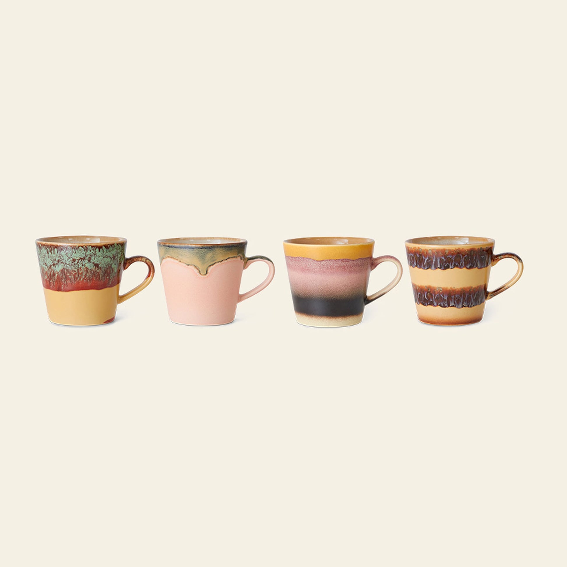 A set of 4 HKliving 70s Ceramics cappuccino mugs, each with a unique earthy-toned glaze and handles, are arranged side by side on a plain light background.