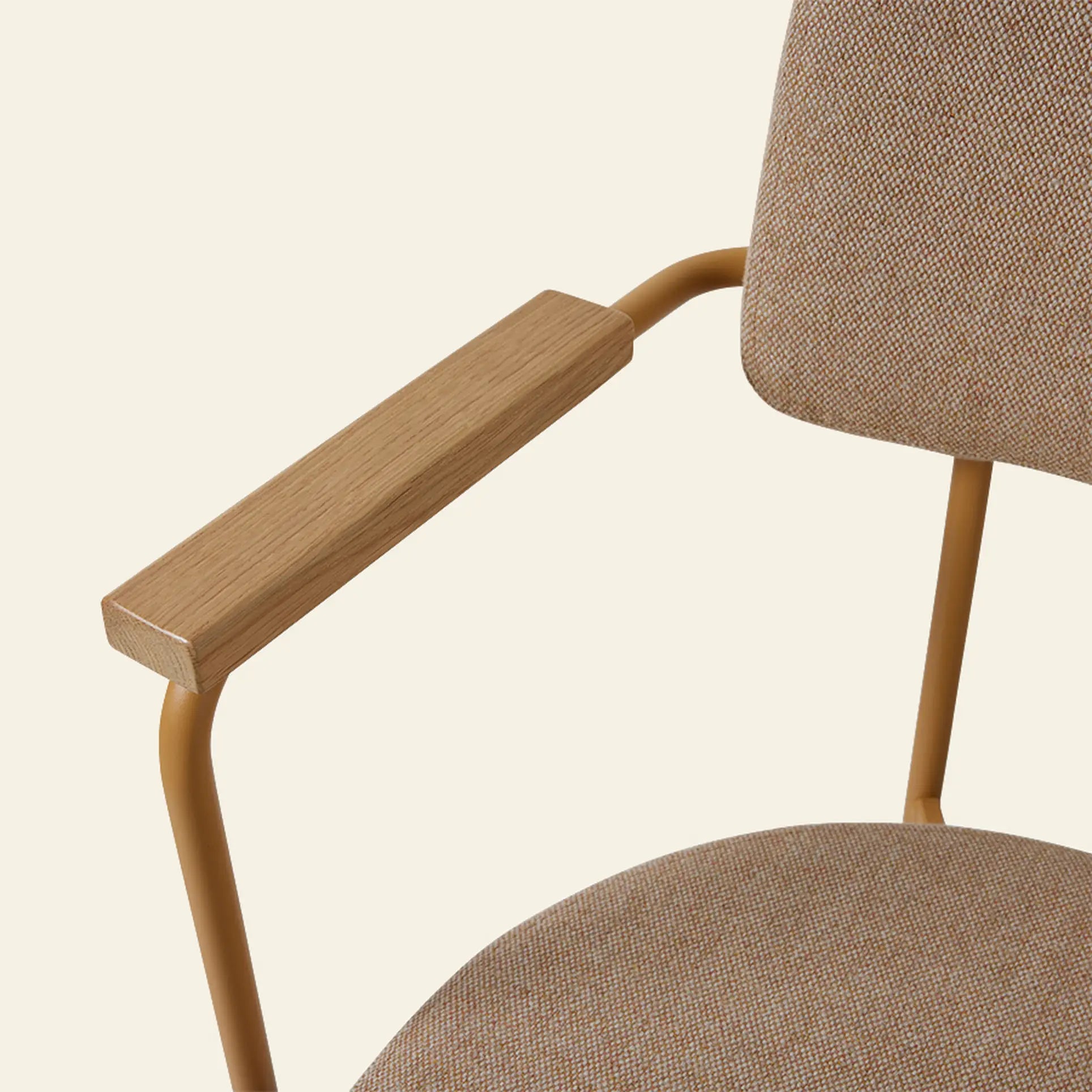 A close-up of the HKliving Dining Armchair, Main Line Flax, Dusty by HKliving, showing its Dutch-inspired design with a tan fabric seat and backrest, wooden armrest, and slim gold frame set against a light beige background.