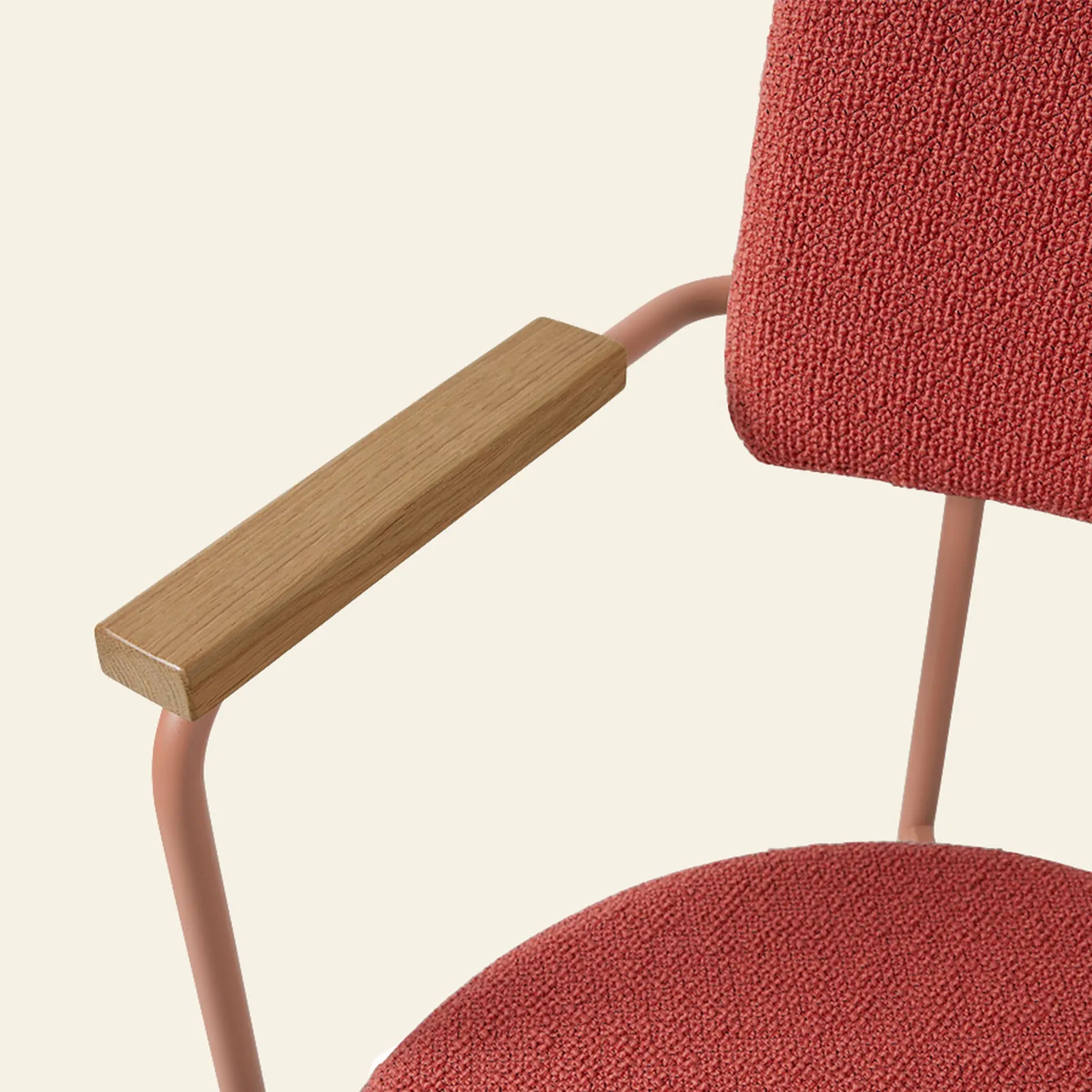 Close-up of the HKliving Dining Armchair, Yoredale, Nude by HKliving, showcasing a pink textured fabric seat and backrest, light brown metal frame, and wooden armrest against an off-white background.
