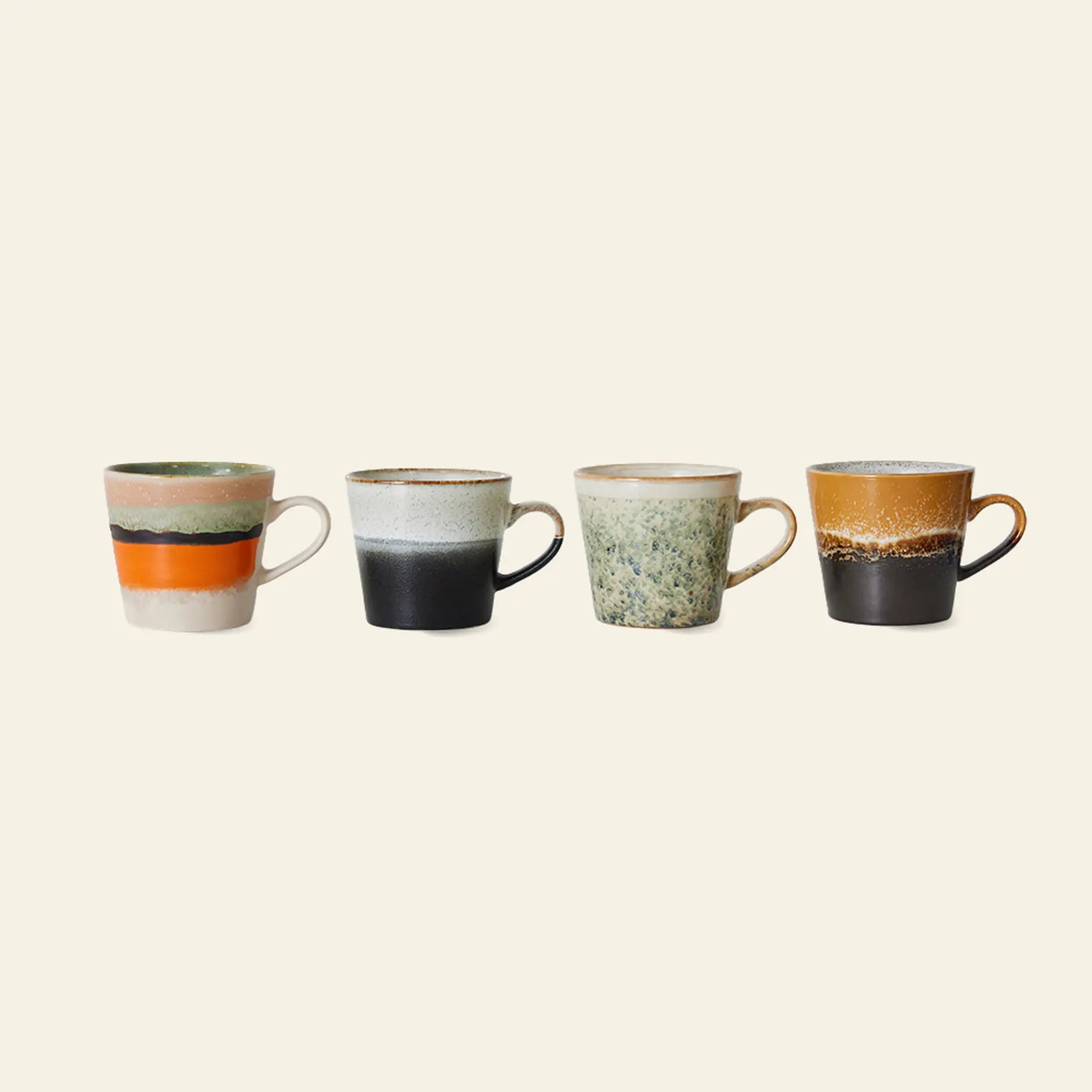 Set of 4 HKliving 70s Ceramics Cappuccino Mugs, each with a unique design—orange & green stripes, black & white, speckled green, and brown & black—ideal for coffee bar decor against a plain beige background.