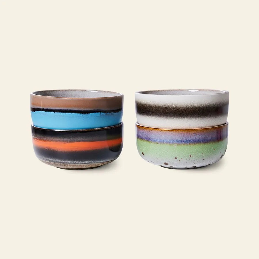 The HKliving 70s Ceramics: Dessert Bowls, Set of 4 features glossy dessert bowls with multicolored horizontal stripes in earthy blue, orange, green, and purple tones, reflecting retro charm on a neutral background.