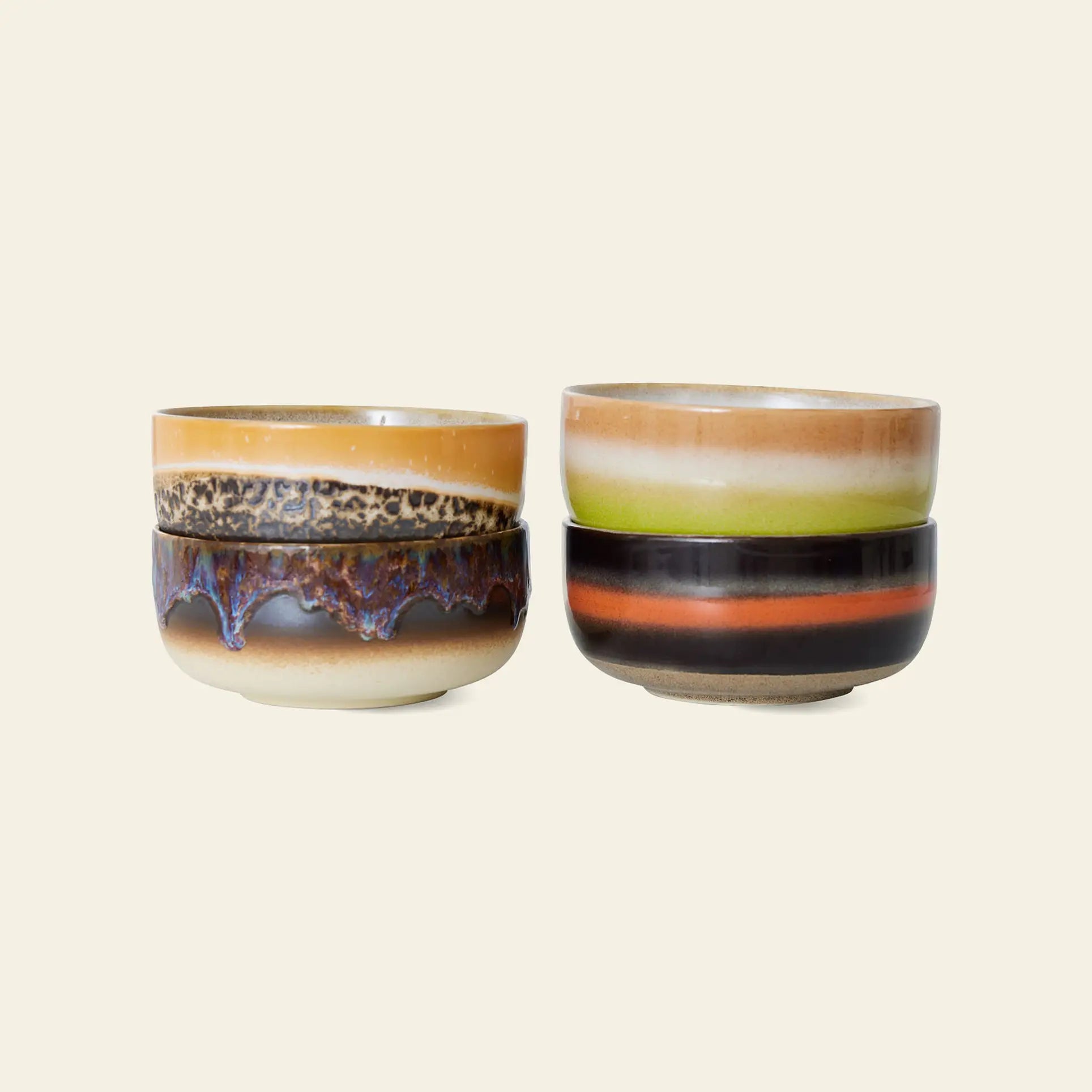 The HKliving 70s Ceramics Dessert Bowls Set of 4 features retro designs in earthy tones of brown, green, orange, purple, and cream, shown stacked in pairs against a light beige background.