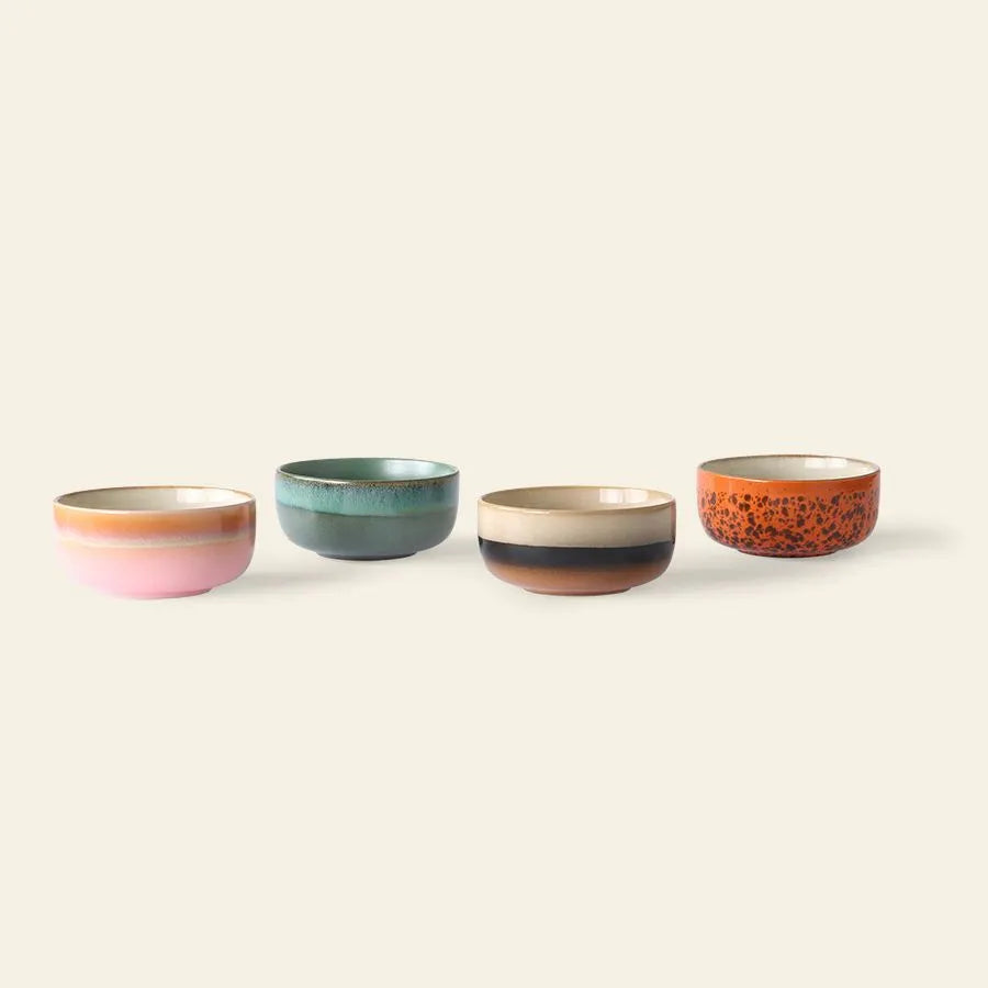 The HKliving 70s Ceramics: Dessert Bowls, Set of 4 features four retro-inspired ceramic bowls in pink, teal, brown with beige, and orange with black speckles, displayed in a row on a light background.