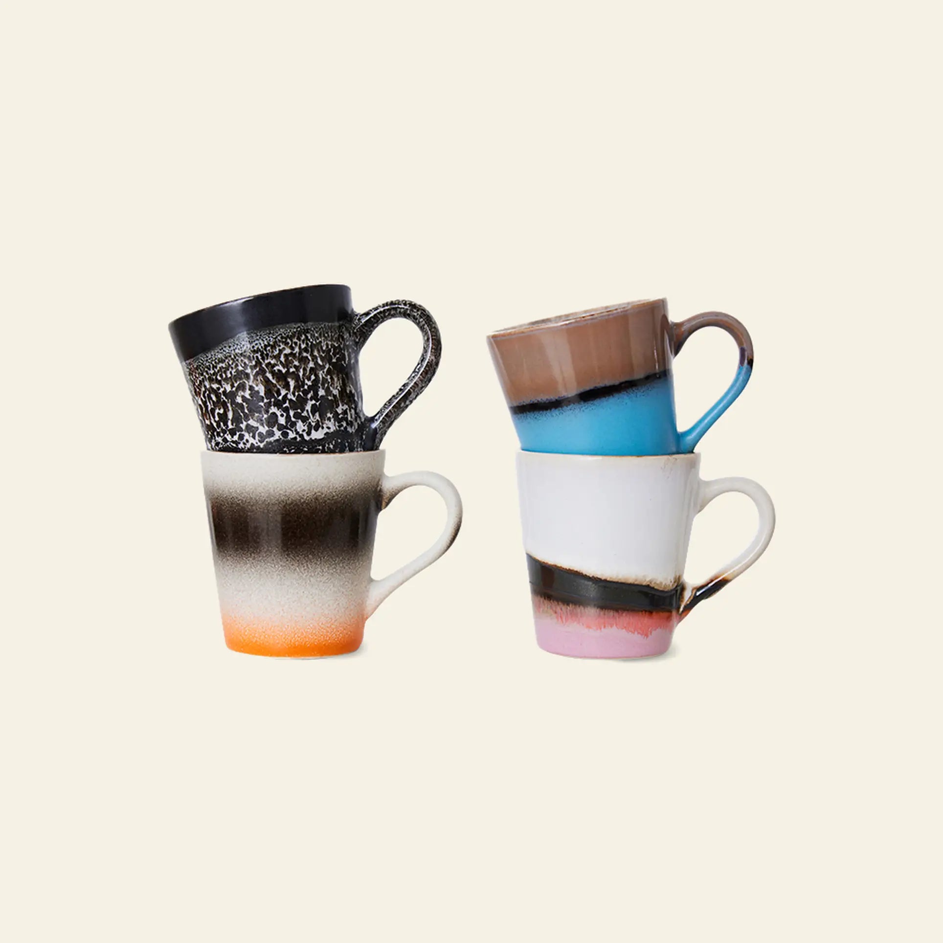 Four HKliving 70s Ceramics espresso mugs are stacked against a plain background. Each 80ml mug features unique color blends and artistic finishes, showcasing the brand’s signature colorful designs and patterns.