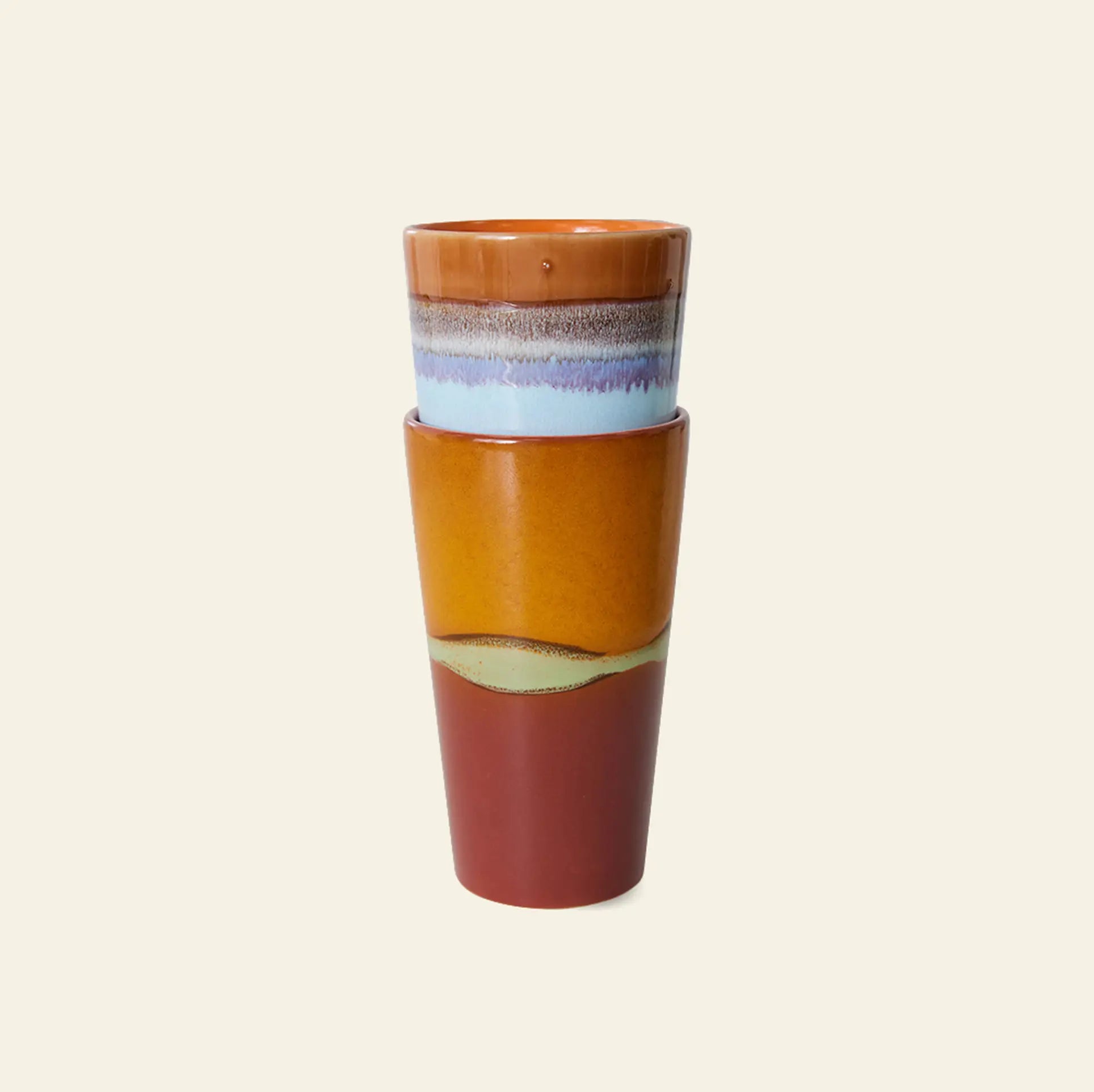 The HKliving 70s Ceramics: Latte Mugs, Set of 2, feature a tall ceramic design with a glossy finish and layered earthy tones—brown, rust, yellow—with a blue band near the rim, all by HKliving. Set against a plain light background.
