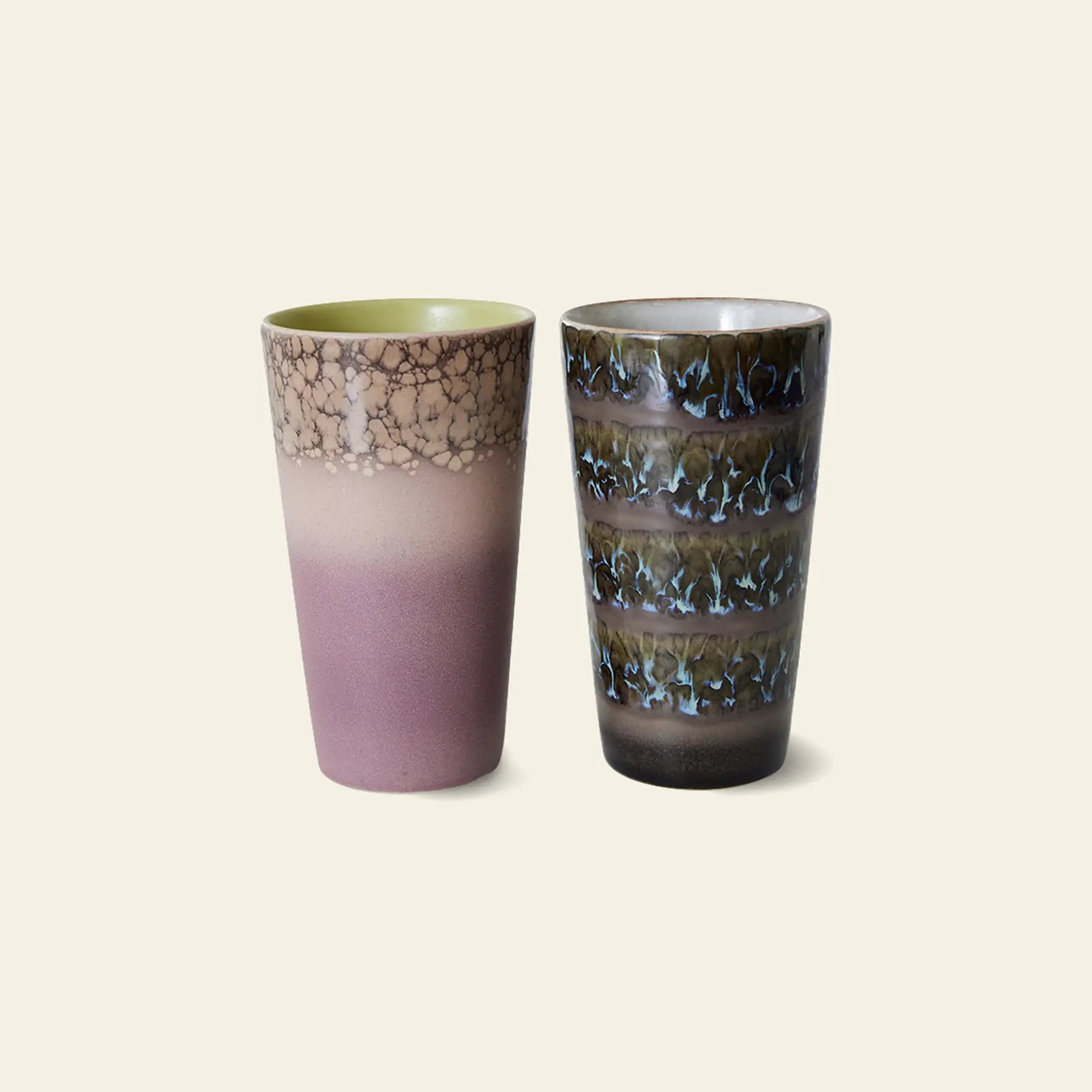 The HKliving 70s Ceramics Latte Mugs, Set of 2, feature artistic glazing: one with purple and brown gradients plus a crackled pattern, the other with dark bands and blue-white drips over brown.