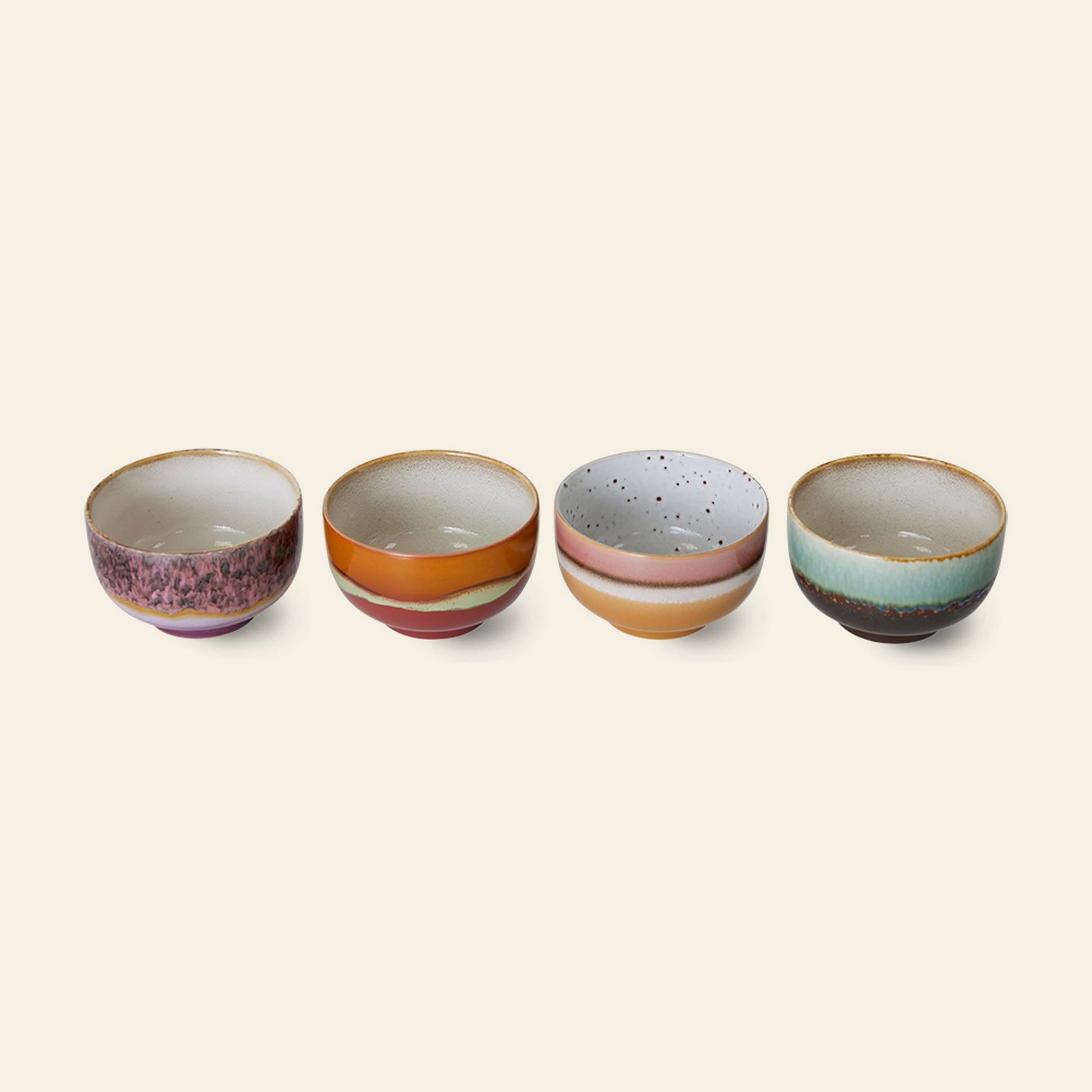 HKliving 70s Ceramics: Noodle Bowls, Set of 4—each featuring unique speckles, stripes, and gradients—are arranged in a row on a plain light background. Perfect for serving your favorite dishes.
