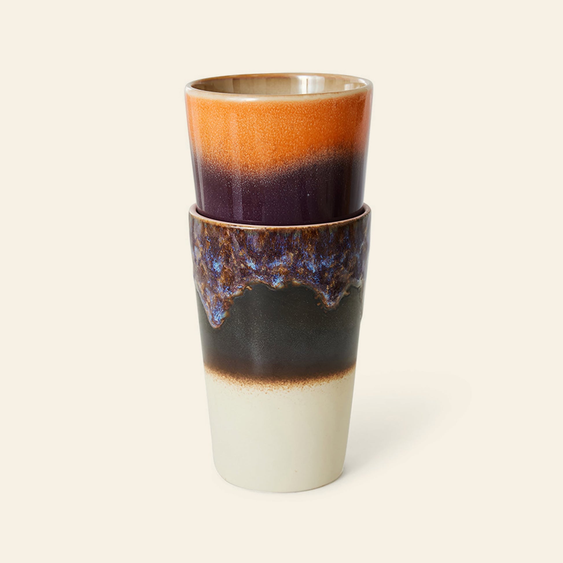 The HKliving 70s Ceramics Tea Mugs Set of 2 features multicolor glazed mugs—one with orange and dark purple hues, the other in textured blue, black, and white—evoking a unique retro 70s style.