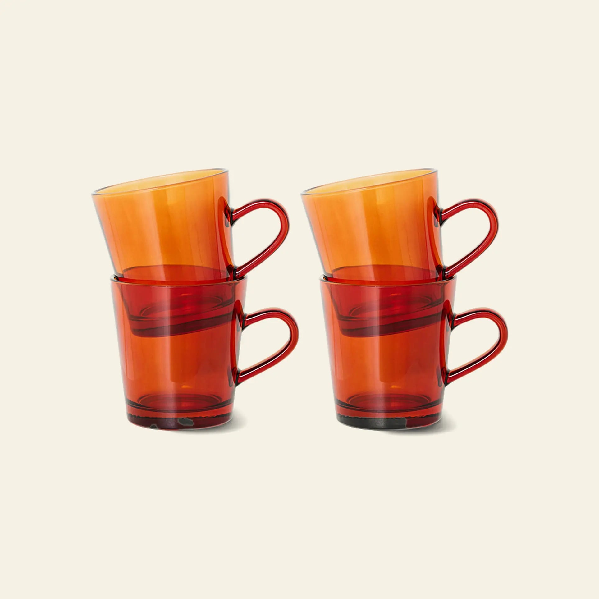Four HKliving 70s Glassware Coffee Cups, stacked in two pairs with one resting diagonally on each, display retro-inspired amber glass by HKliving against a plain light background. Set of 4.