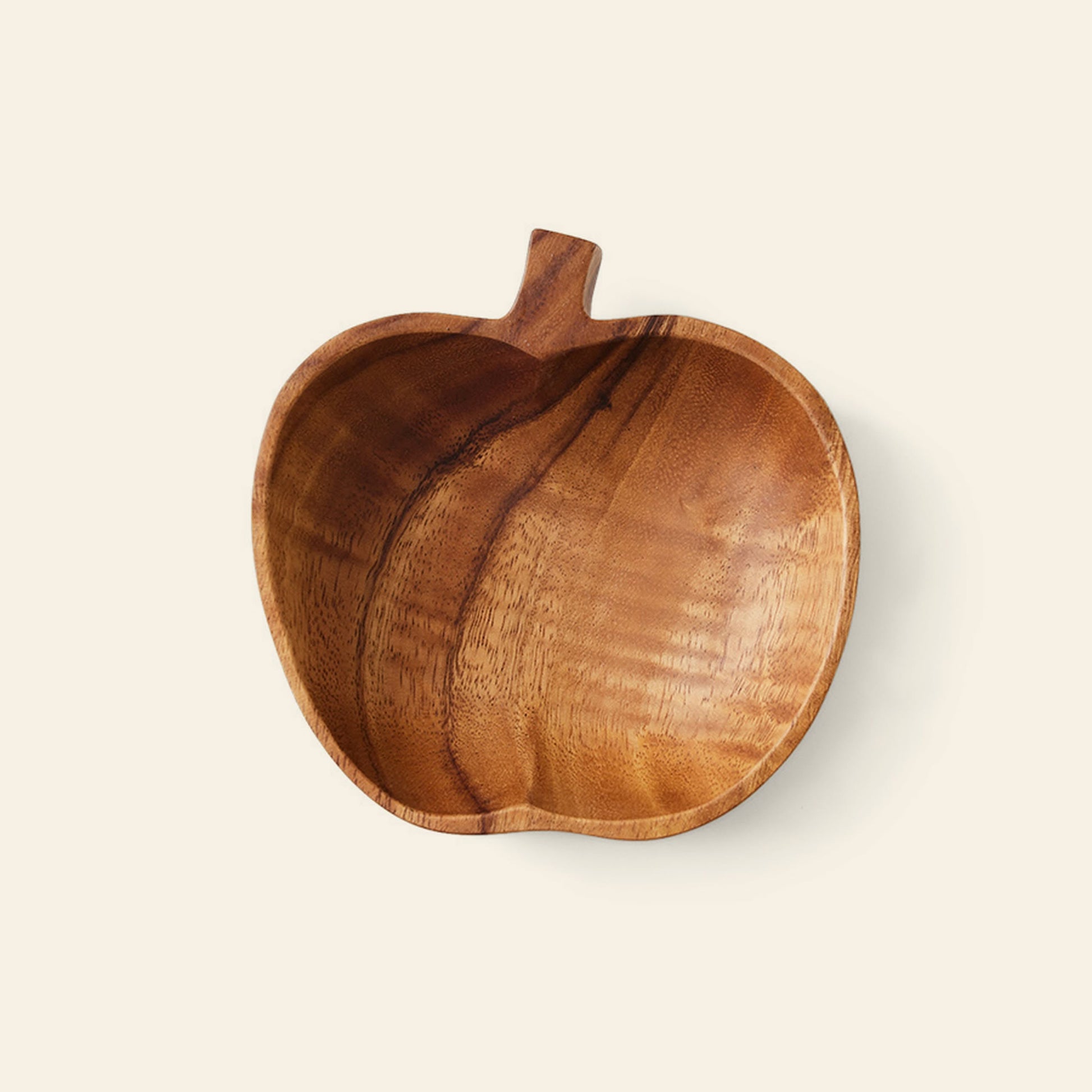 The HKliving Acacia Apple Bowl M by HKliving is a handcrafted apple-shaped bowl made from acacia wood, showcasing a short stem and beautiful natural grain, displayed on a light beige background.