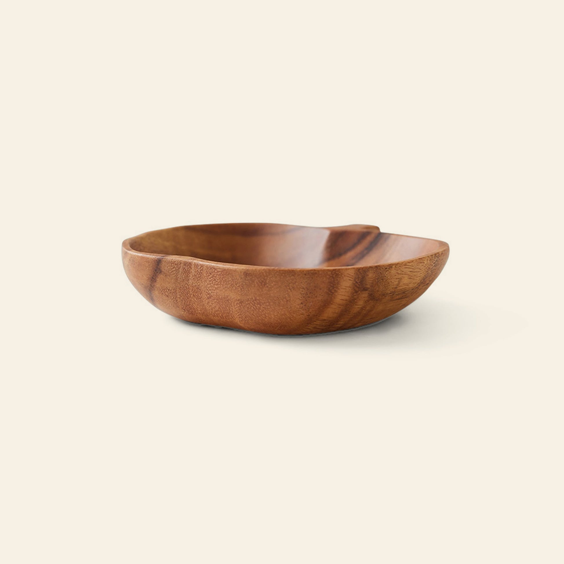 The HKliving Acacia Apple Bowl M by HKliving is a shallow, round acacia wood bowl with a smooth finish. Shown on a light beige background, its visible grain showcases handcrafted artistry and rustic charm.