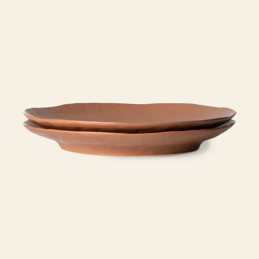 Two stacked HKliving Bold & Basic Ceramics side plates, set of 2, feature oval stoneware shapes with wavy edges and a natural earthy brown finish, displayed on a light beige background.