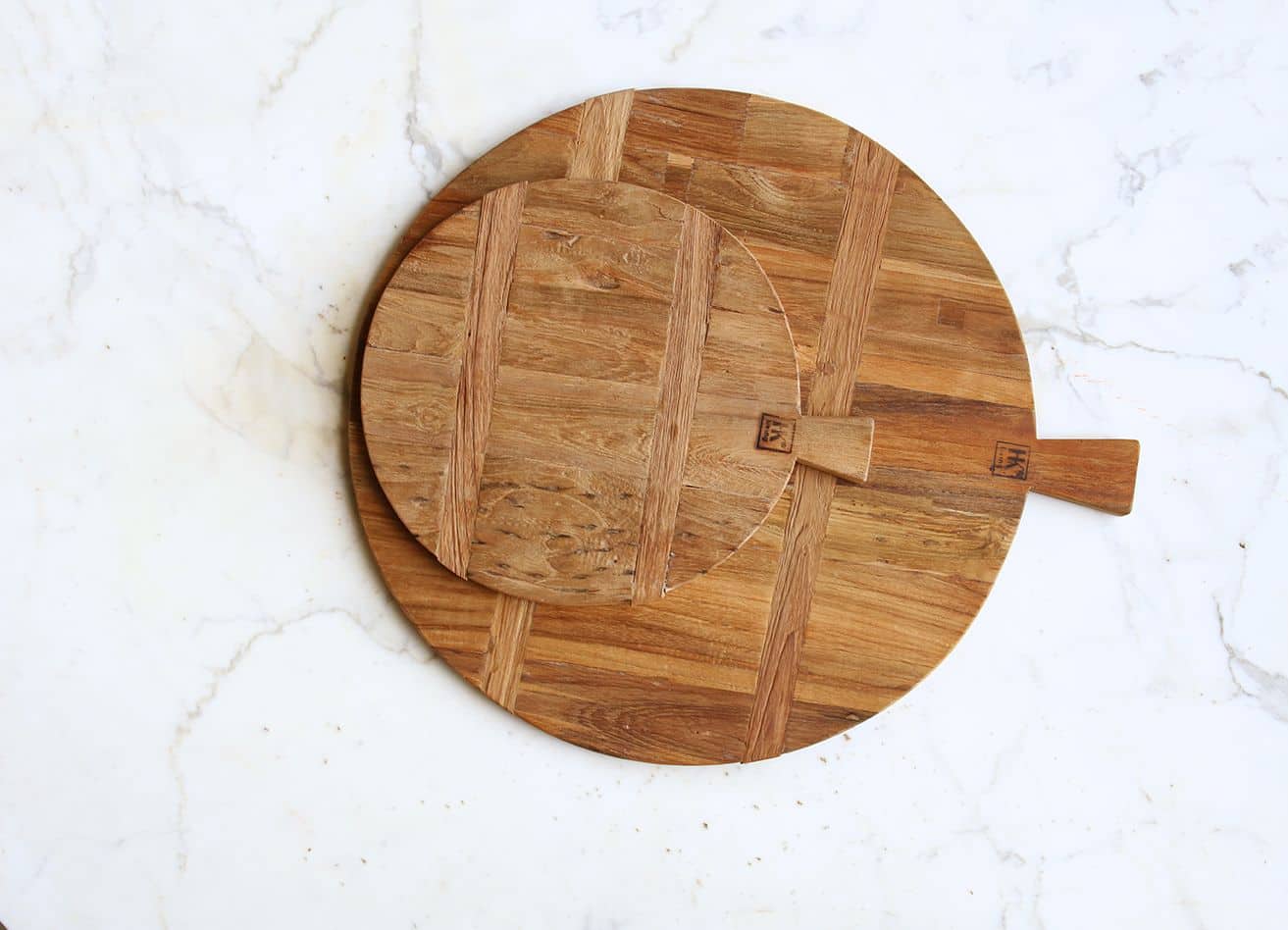 Two HKliving Bread Board Reclaimed Teak, Medium boards are stacked on white marble. Their rustic wood tones add warmth, with one board slightly off-center atop the other. Brand: HKliving.