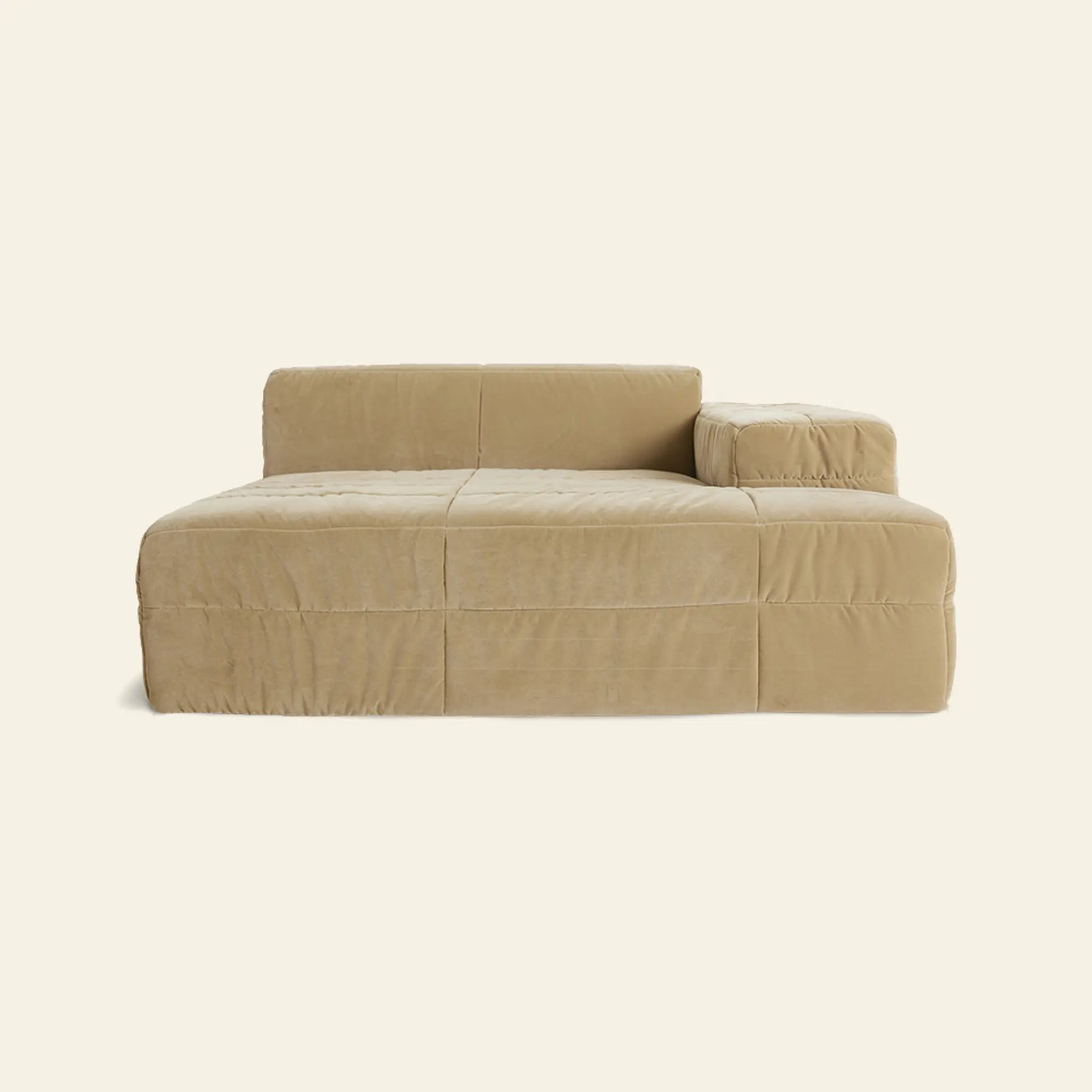 The HKliving Brut Sofa, Right Divan by HKliving is a modern beige sectional with spacious seating, a low backrest, and an attached right armrest, upholstered in soft fabric and shown against a plain light background.