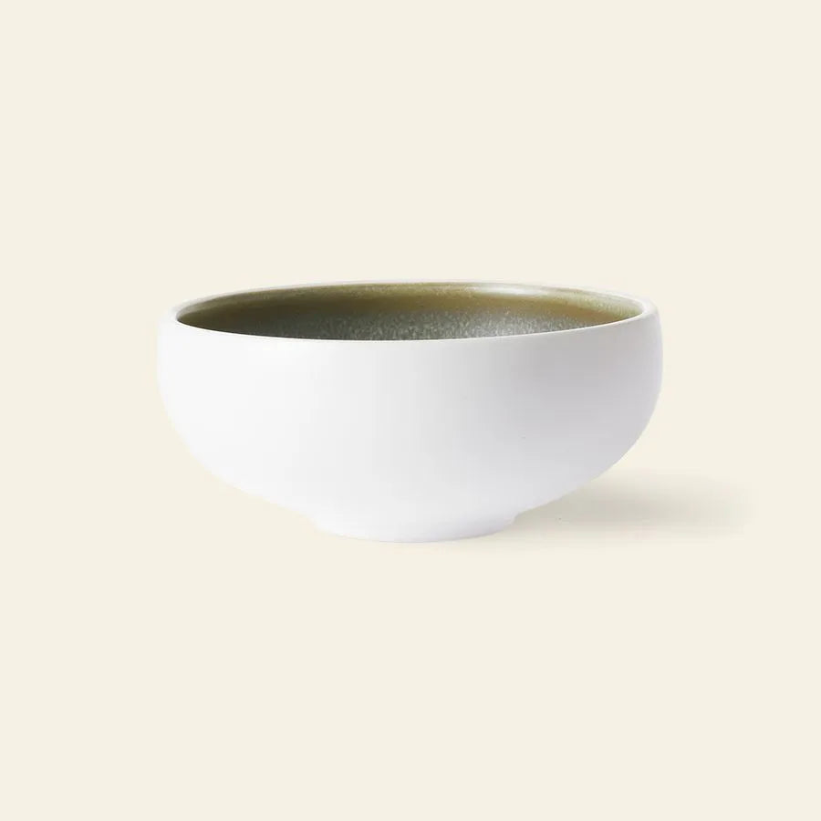 The HKliving Chef Ceramics: Bowl by HKliving features a hand-finished white ceramic exterior and glossy greenish interior, set against a light beige background—an elegant addition to your tableware.